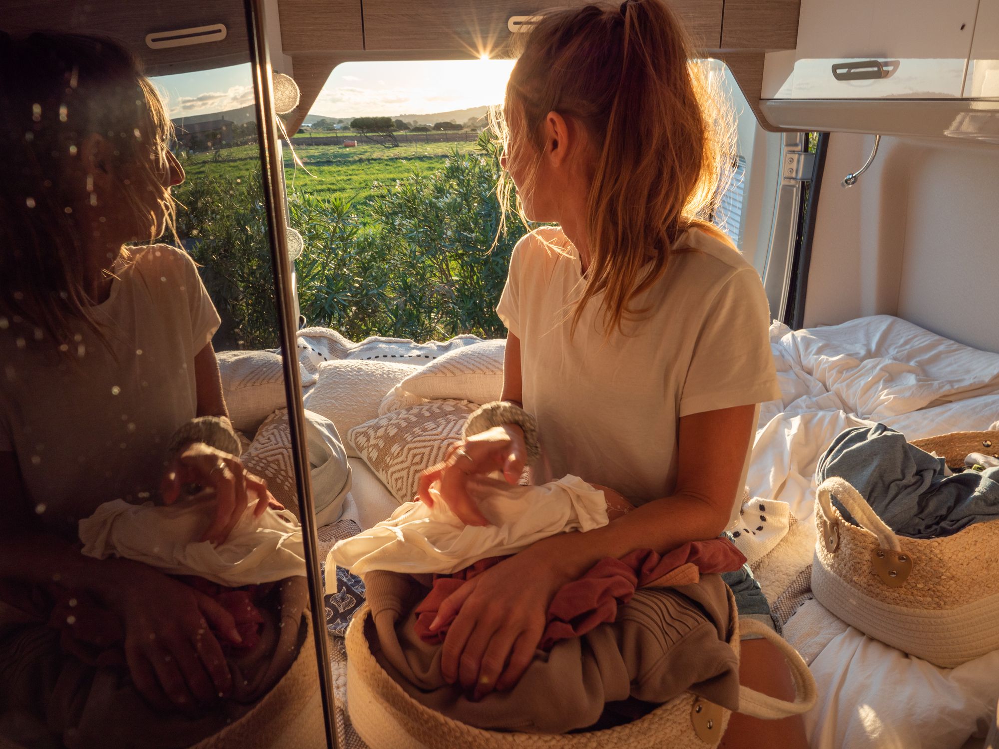 Road trip concept, woman living the van life experience. She prepares the dirty cloths to wash at the back of her camper