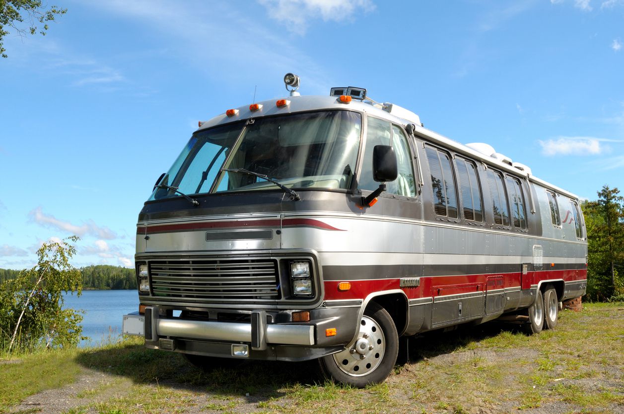 Large Luxury motorhome parked in front of a lake