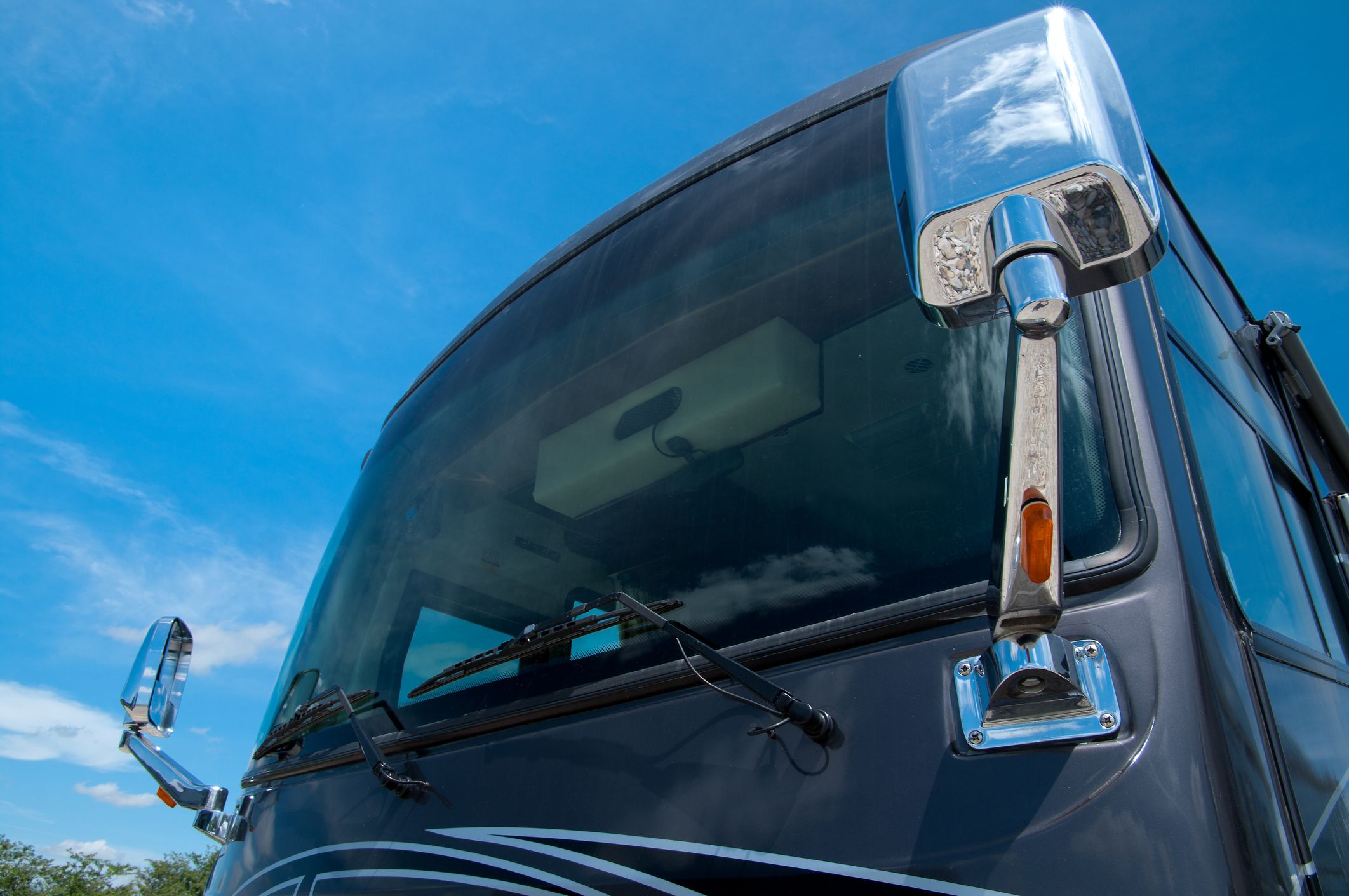 Close up view of a large recreational vehicles windshield.
