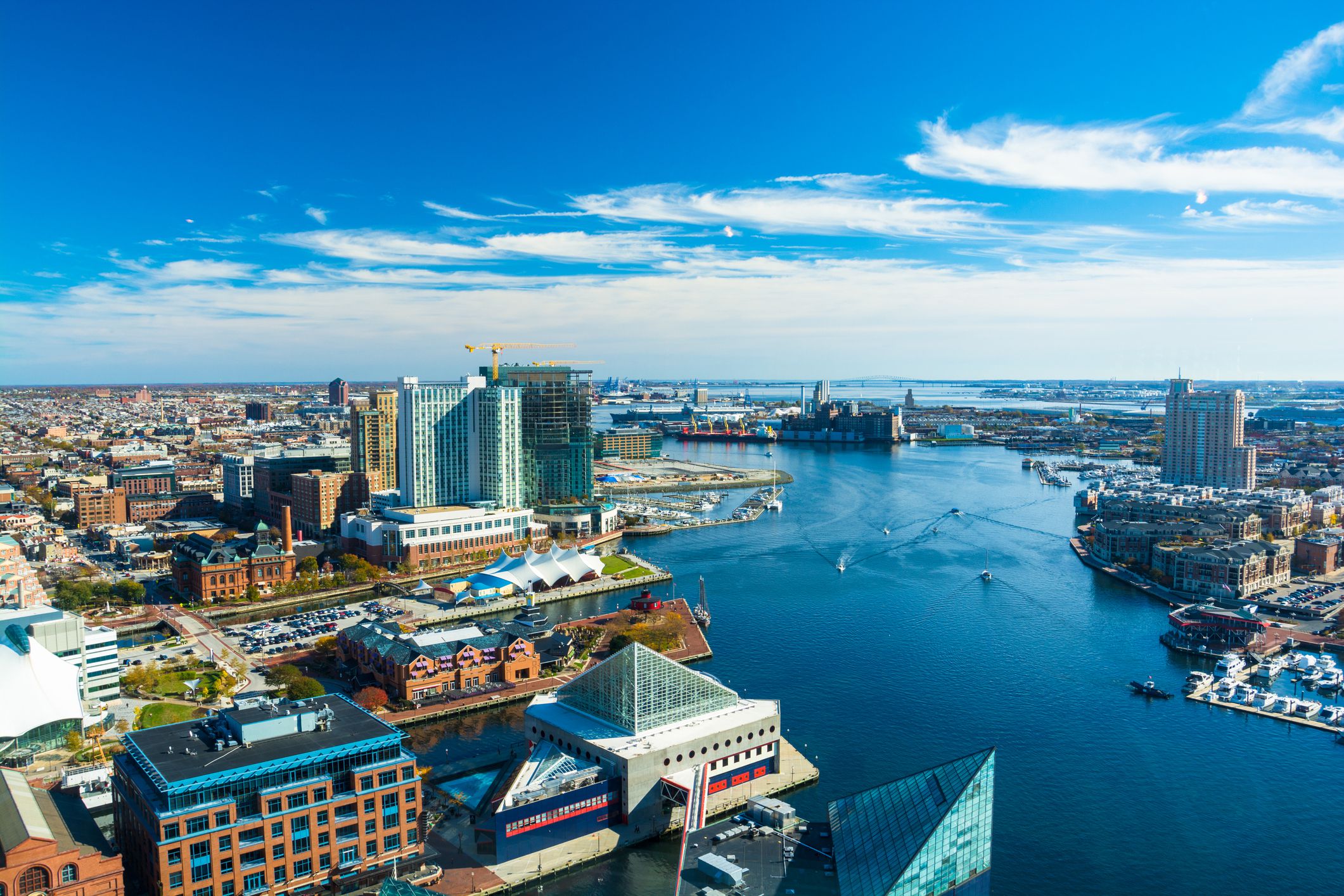 Aerial of Baltimore City with the Patapsco River and waterfront buildings. Harbor East and Fells Point neighborhoods is shown on the left and the Tide Point neighborhood is shown on the right.