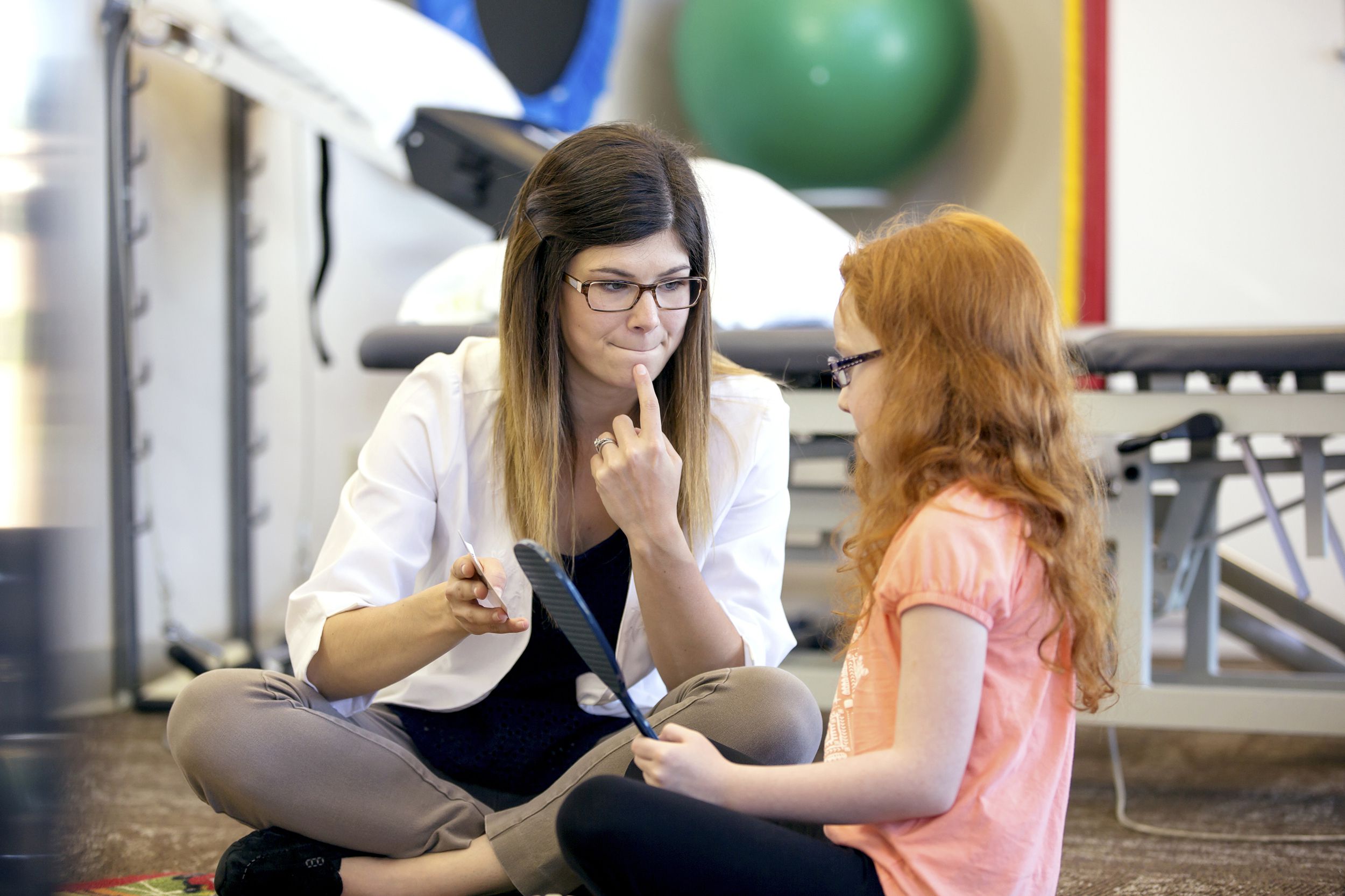 young female speech therapist helping a young patient