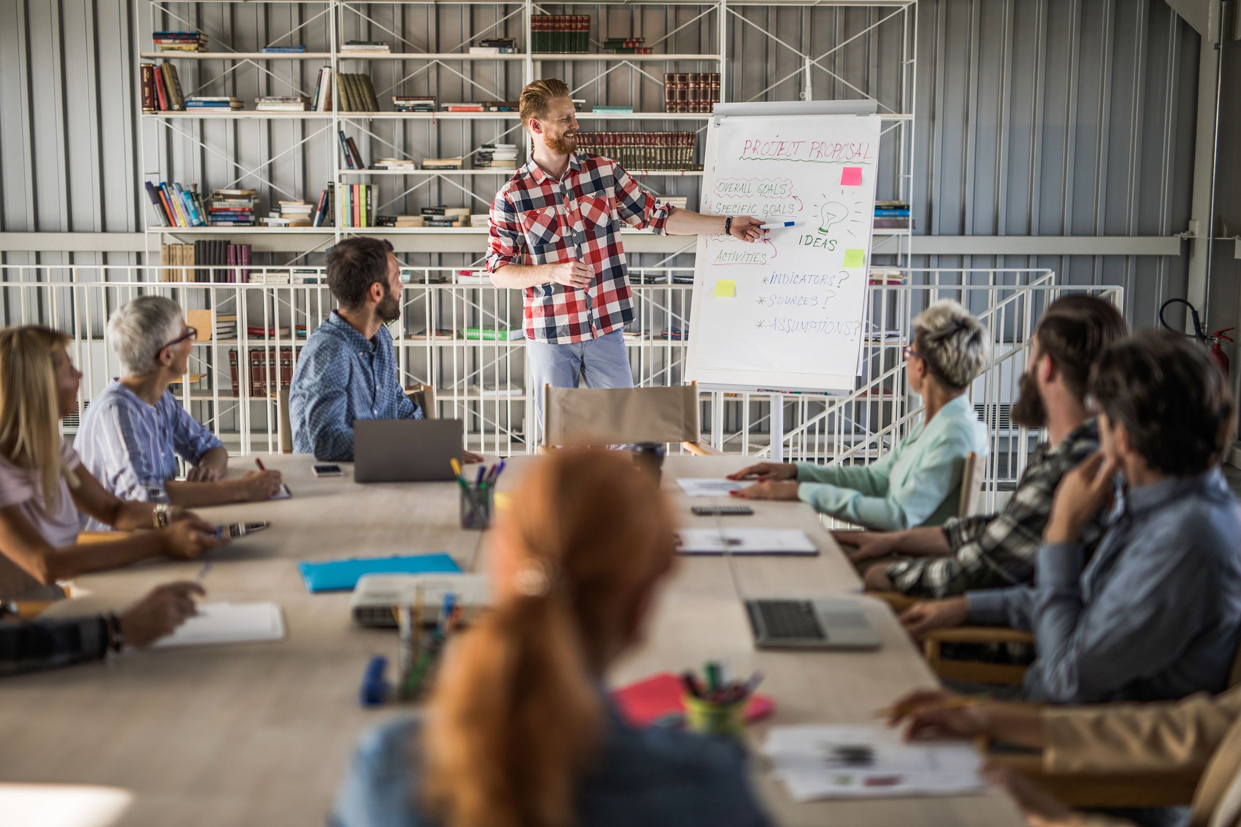 happy entrepreneur presenting his coworkers new business strategy on a meeting