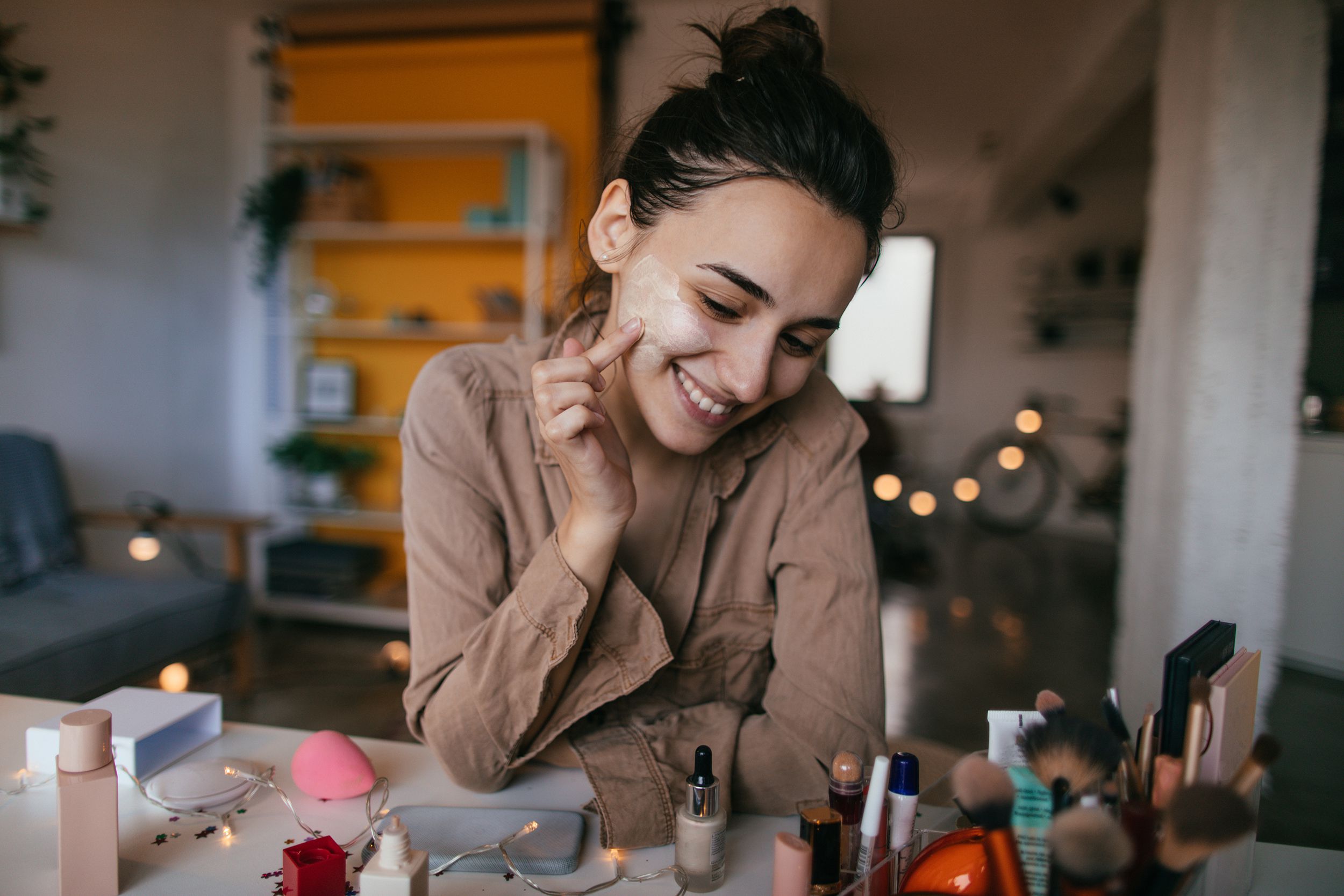 young woman applying daily cream at desk