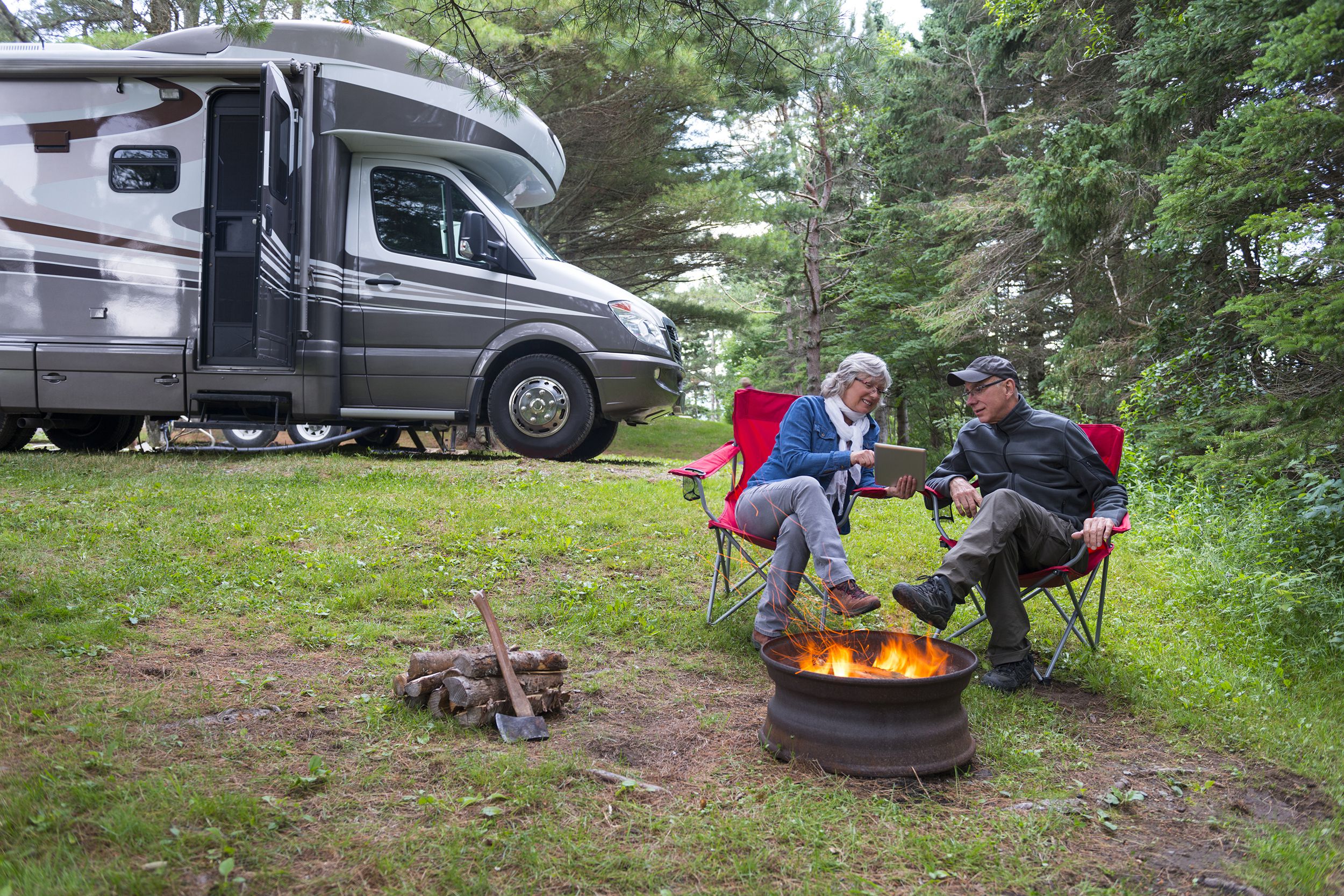 couple using digital tablet near campfire