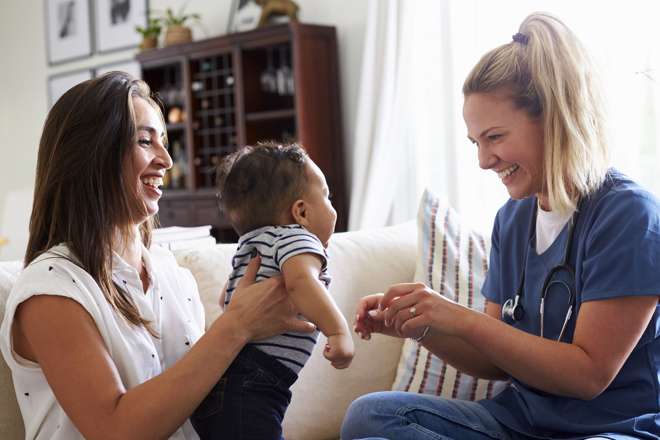 female healthcare worker visiting a young mum and her infant son at home