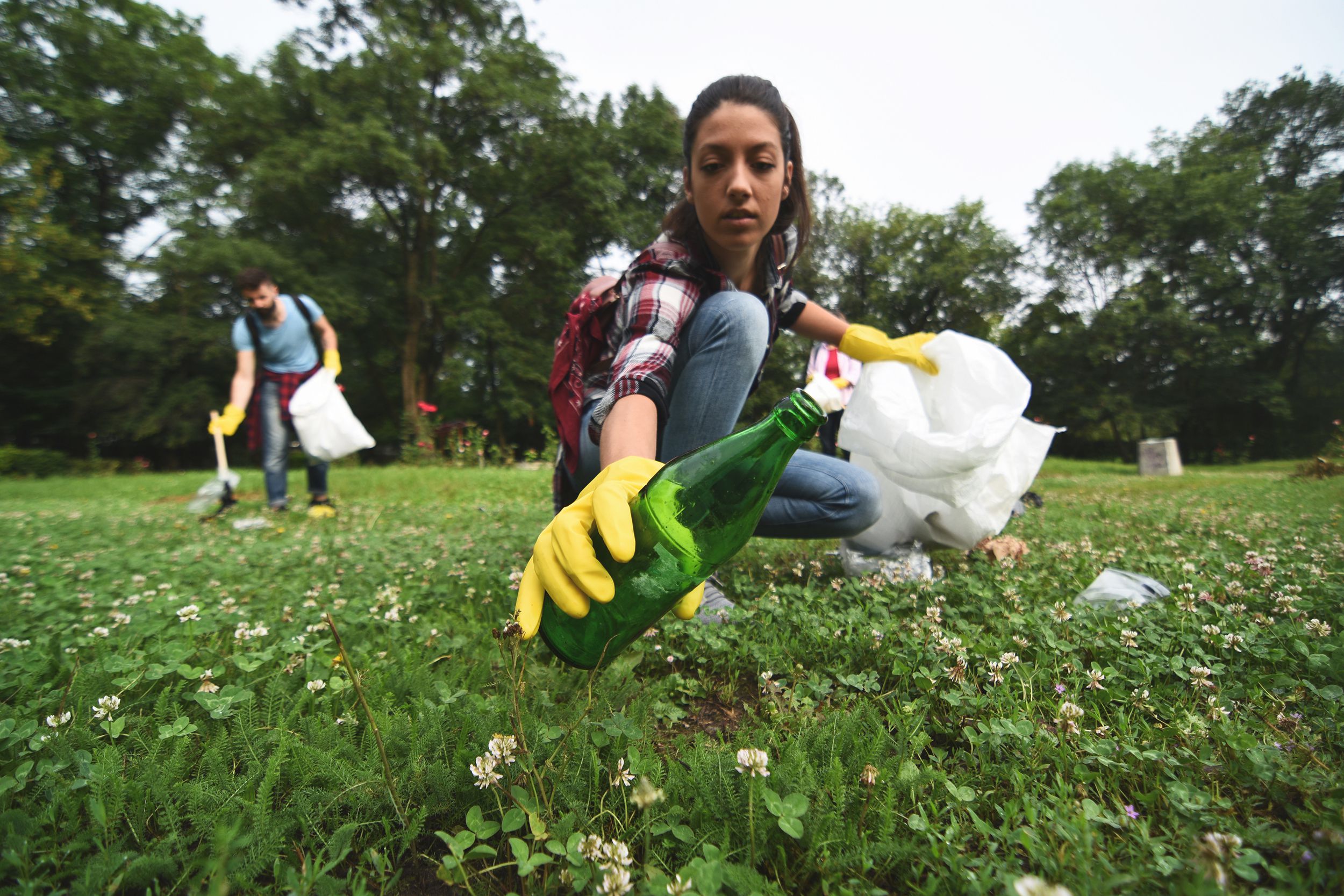 couple picking up trash in park