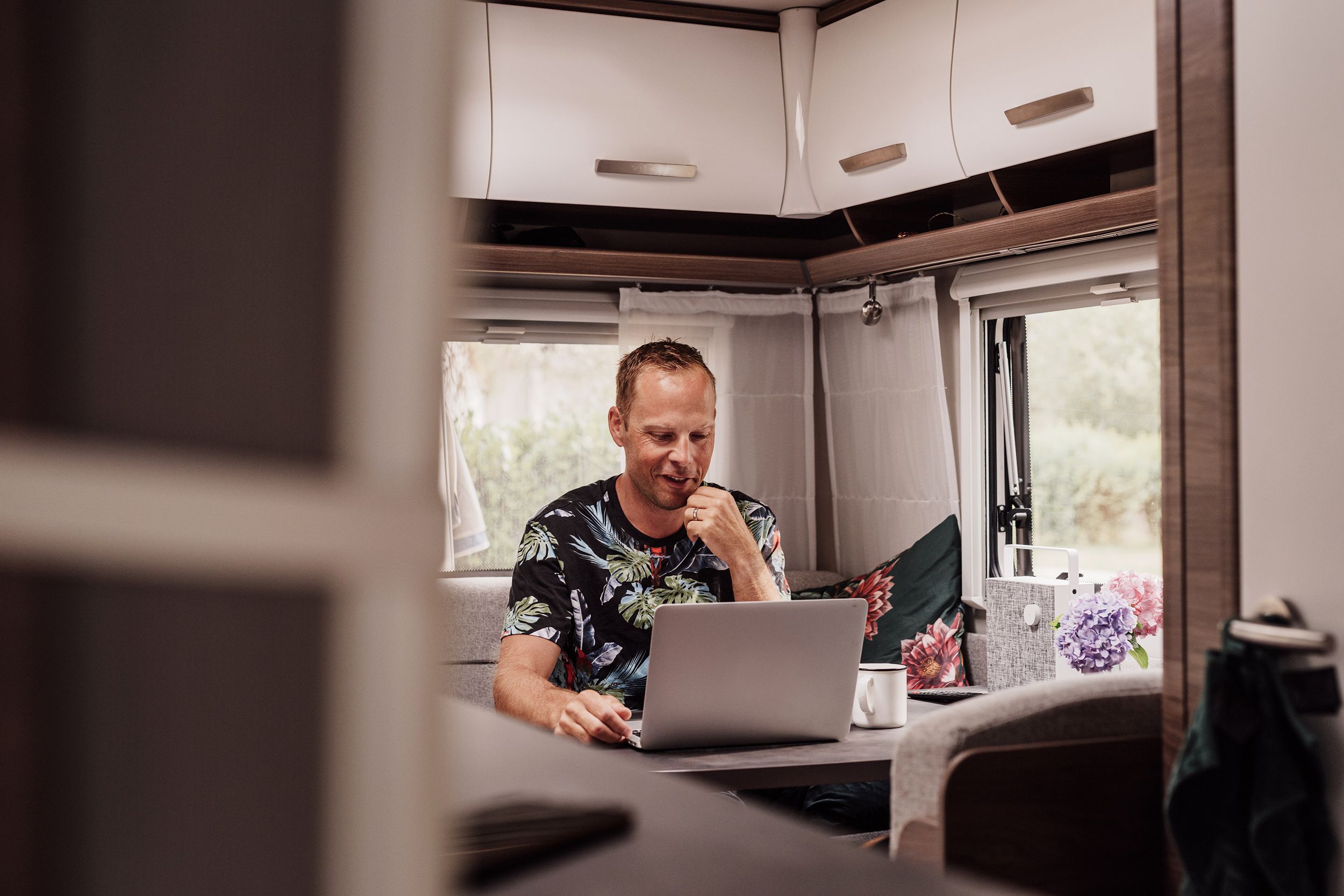 man on laptop in kitchen area of rv