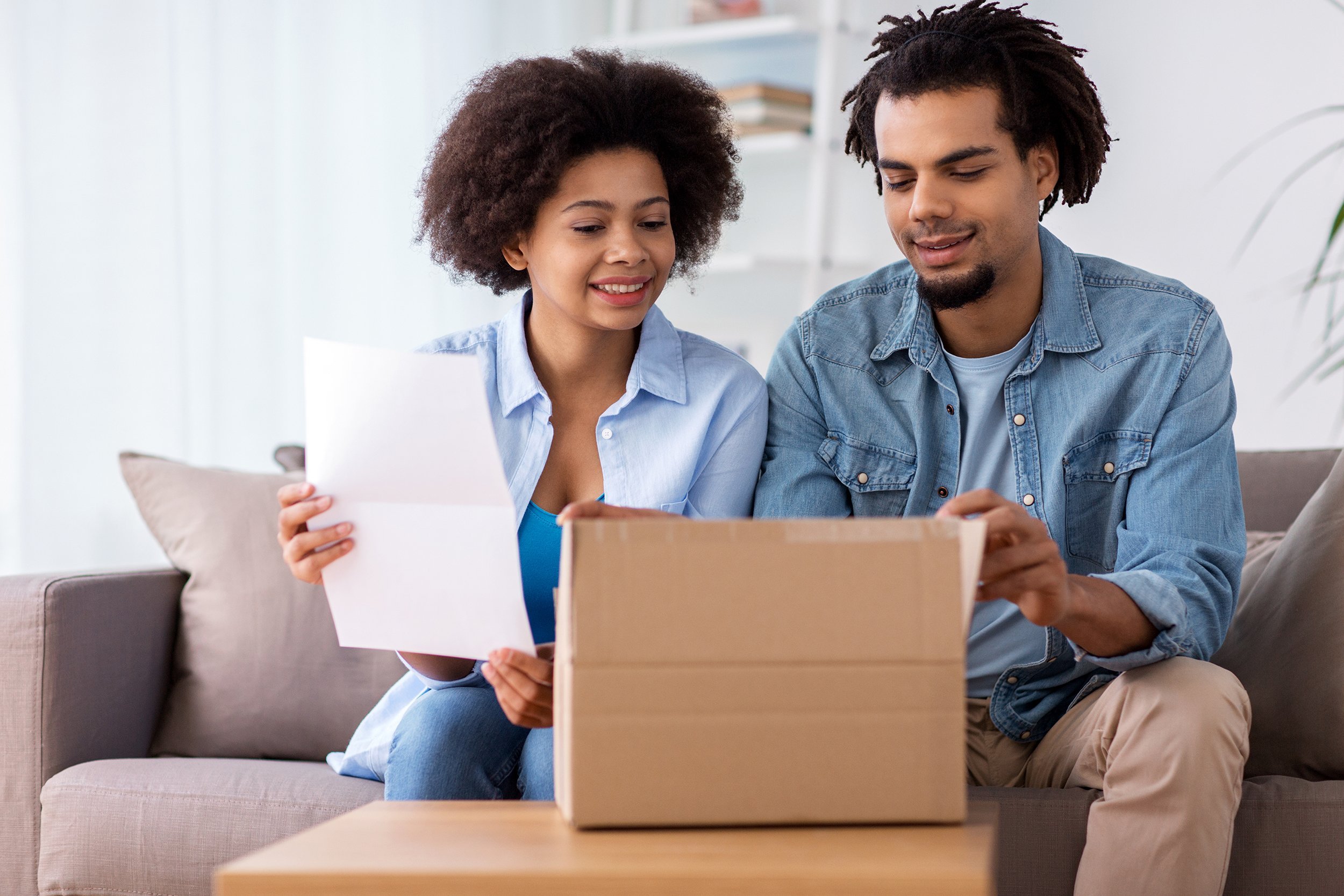 happy couple with parcel box and paper form home