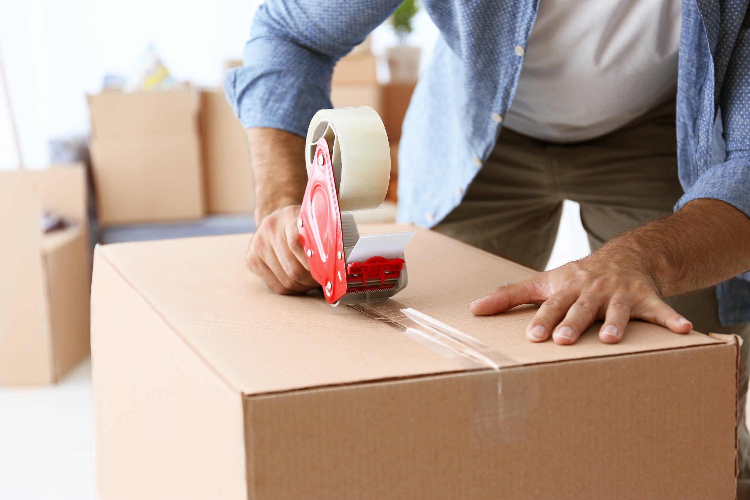 man packing cardboard box