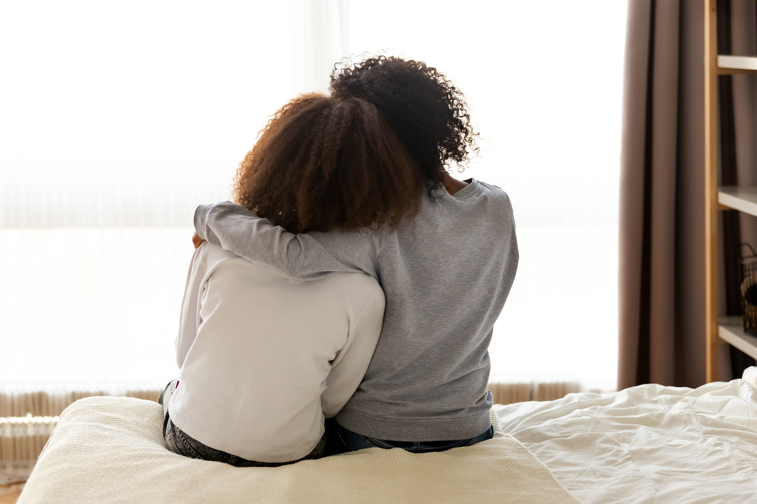Mother and daughter hugging on couch