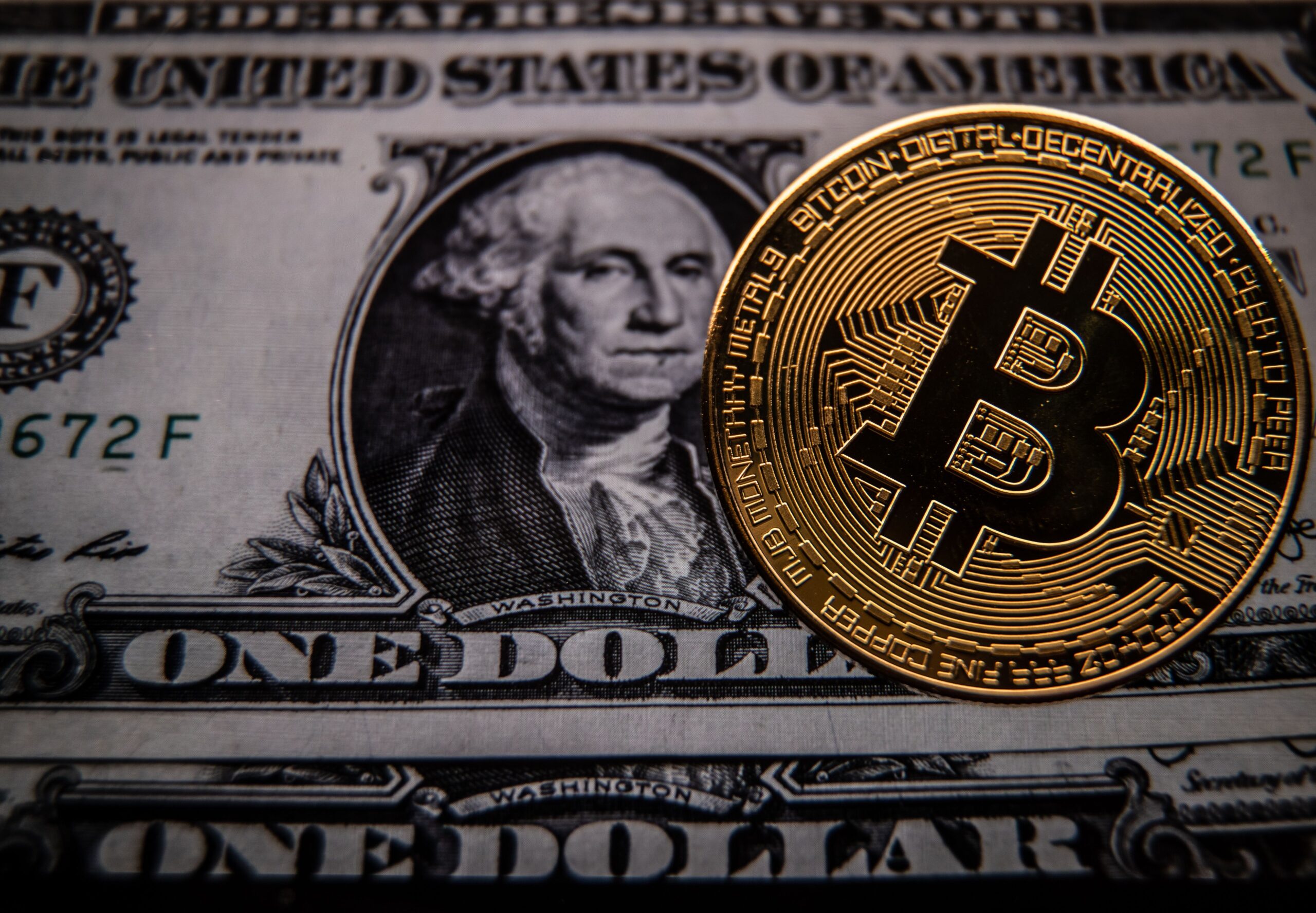 n this photo illustration a novelty Bitcoin token is photographed with a US dollar bank note, on March 13, 2022 in Bristol, England.