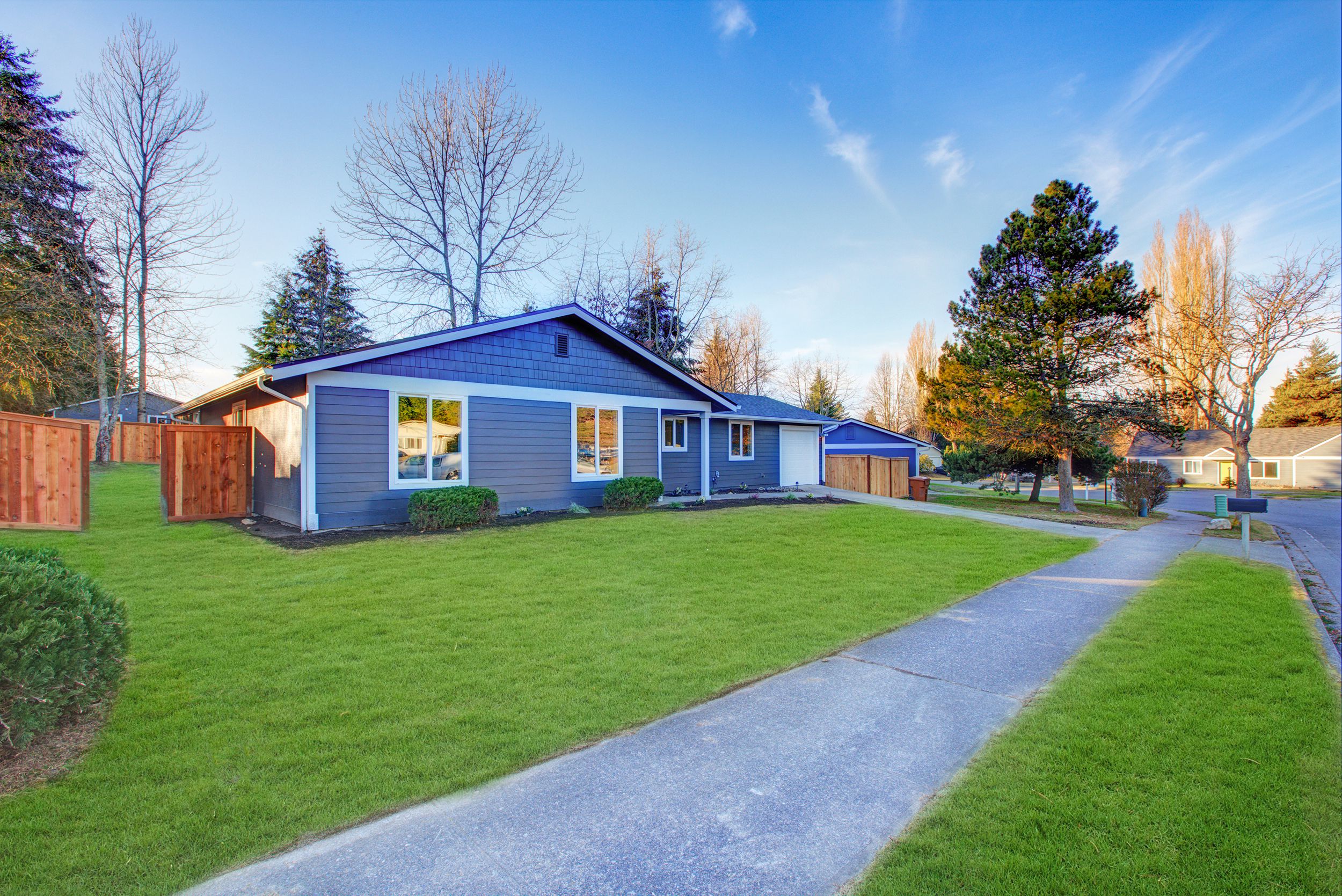 Blue one-story low-pitched roof home in Tacoma, Washington, sunny day in winter with no snow