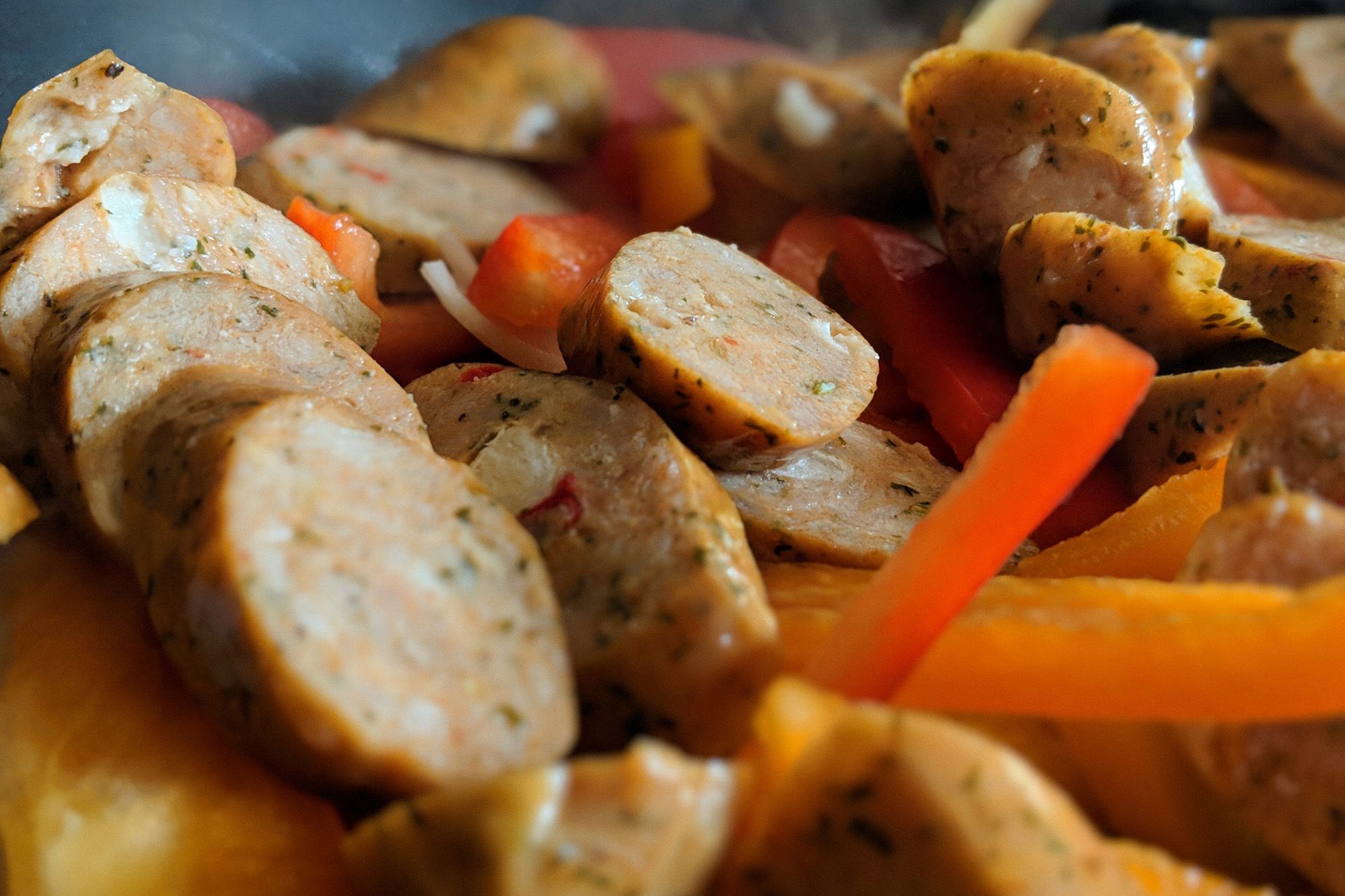 Cooked chicken sausage and sliced red and orange peppers