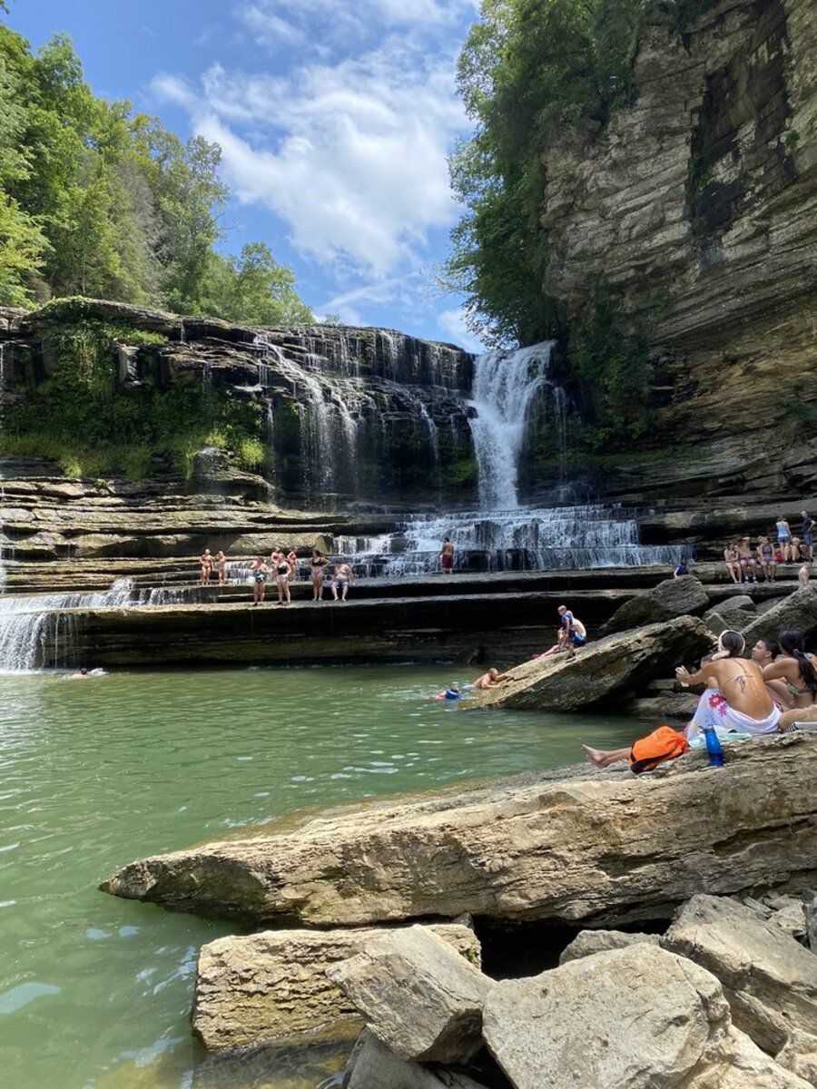 Cummins Falls, Jackson County, Tennessee, waterfalls and swimming hole, with people enjoying both on a bright sunny day in summer