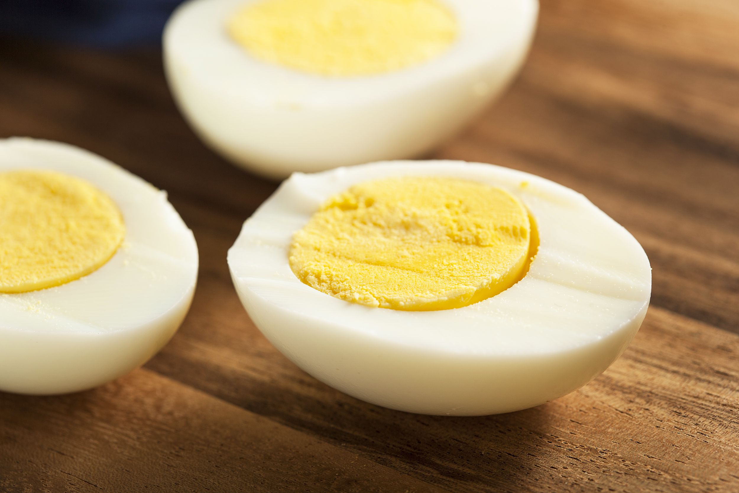Hard Boiled Eggs cut in half on a wooden chopping board