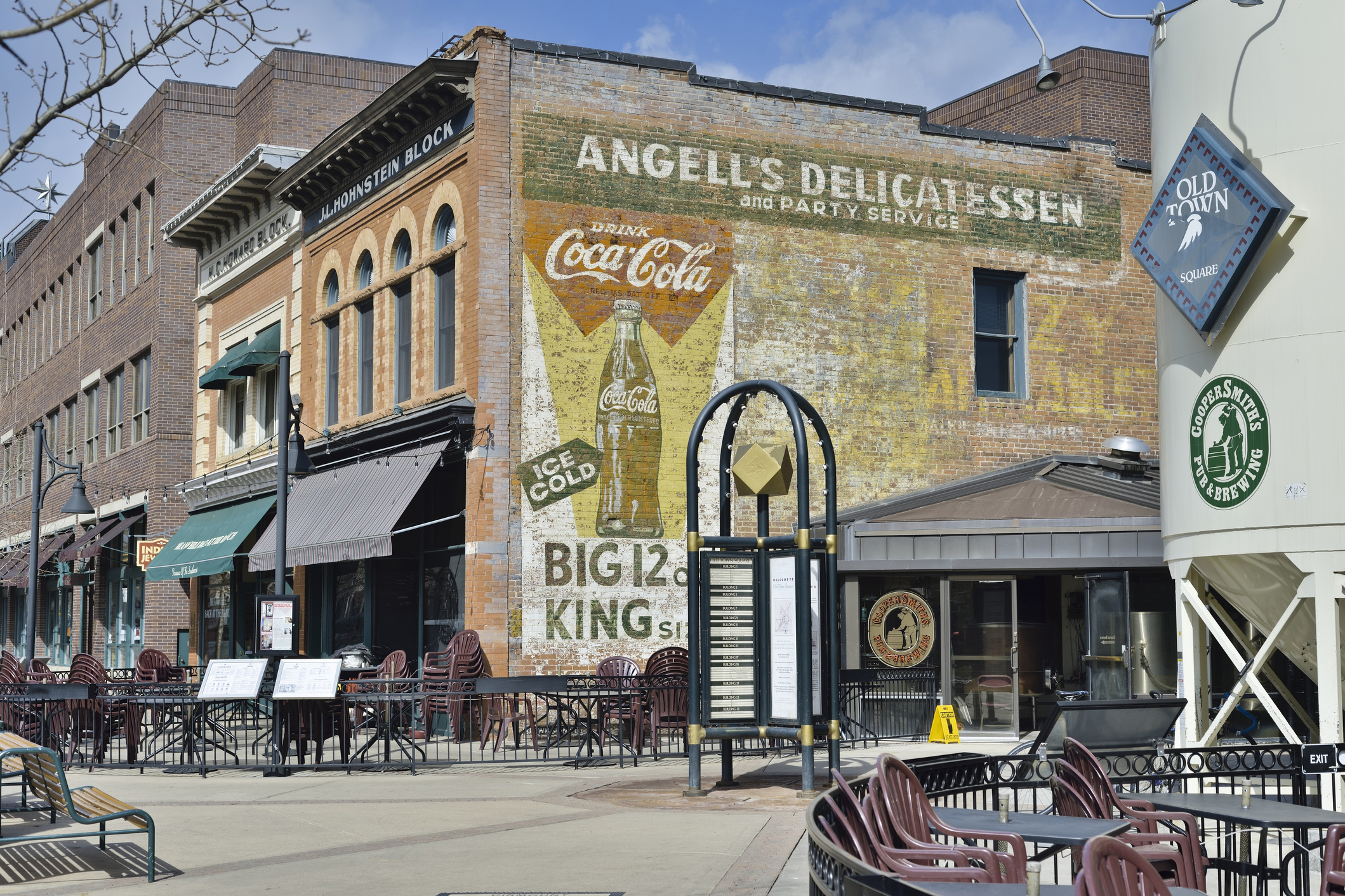 Historic buildings in the Old Town District of Fort Collins, Colorado, sidewalk with seating in the foreground, on a bright sunny day