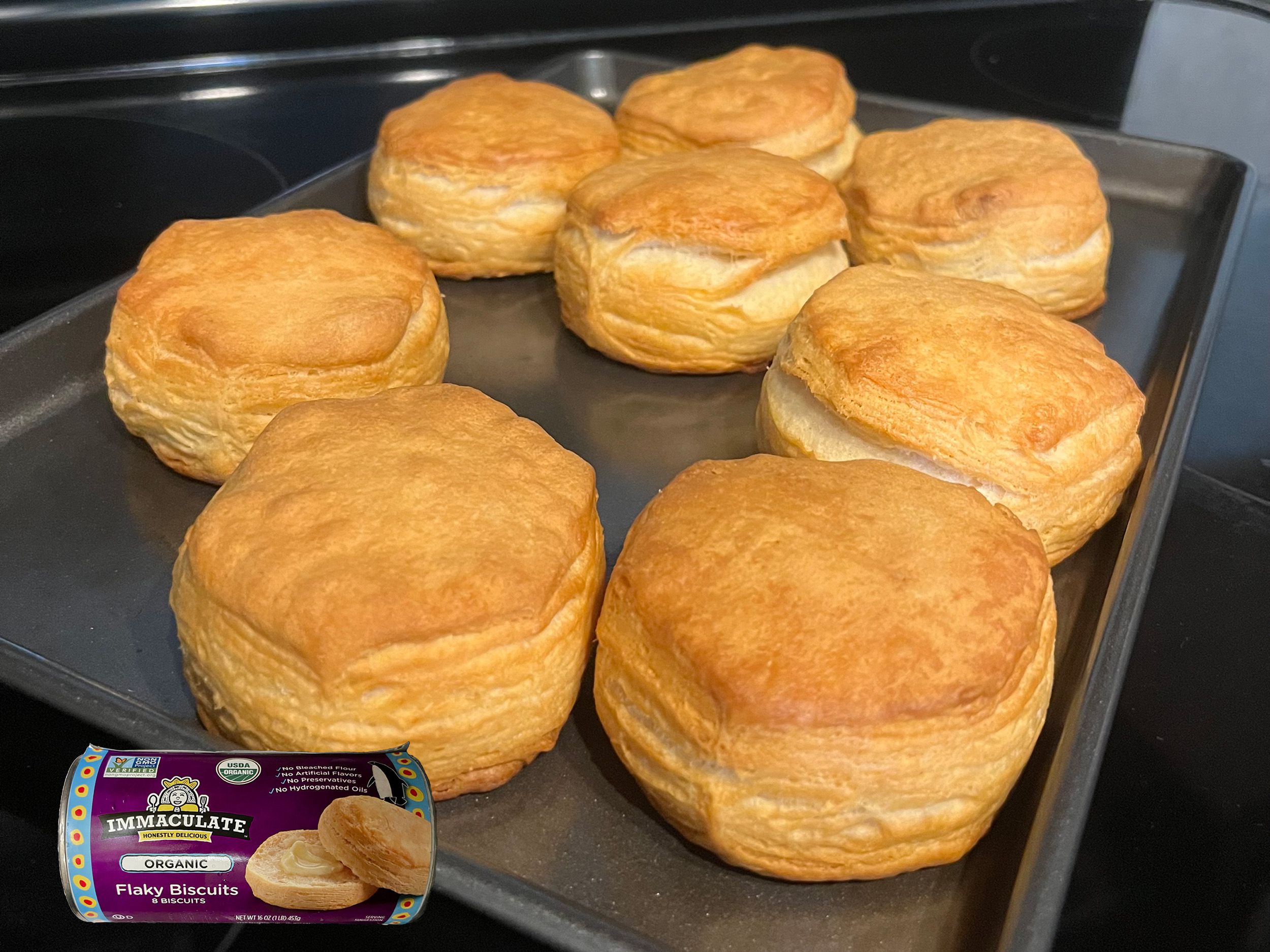 Immaculate Organic Flaky Biscuits baked on a tray with overlay of product can