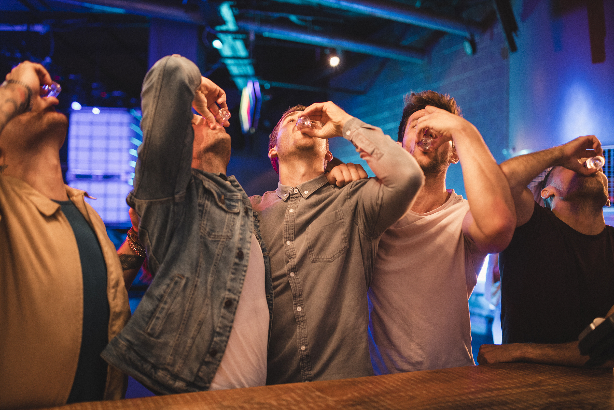 Men in bar taking shots