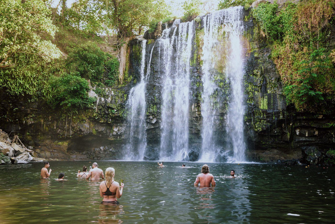 Llanos de Cortés Waterfall, Bagaces, Costa Rica with people in swimming hole