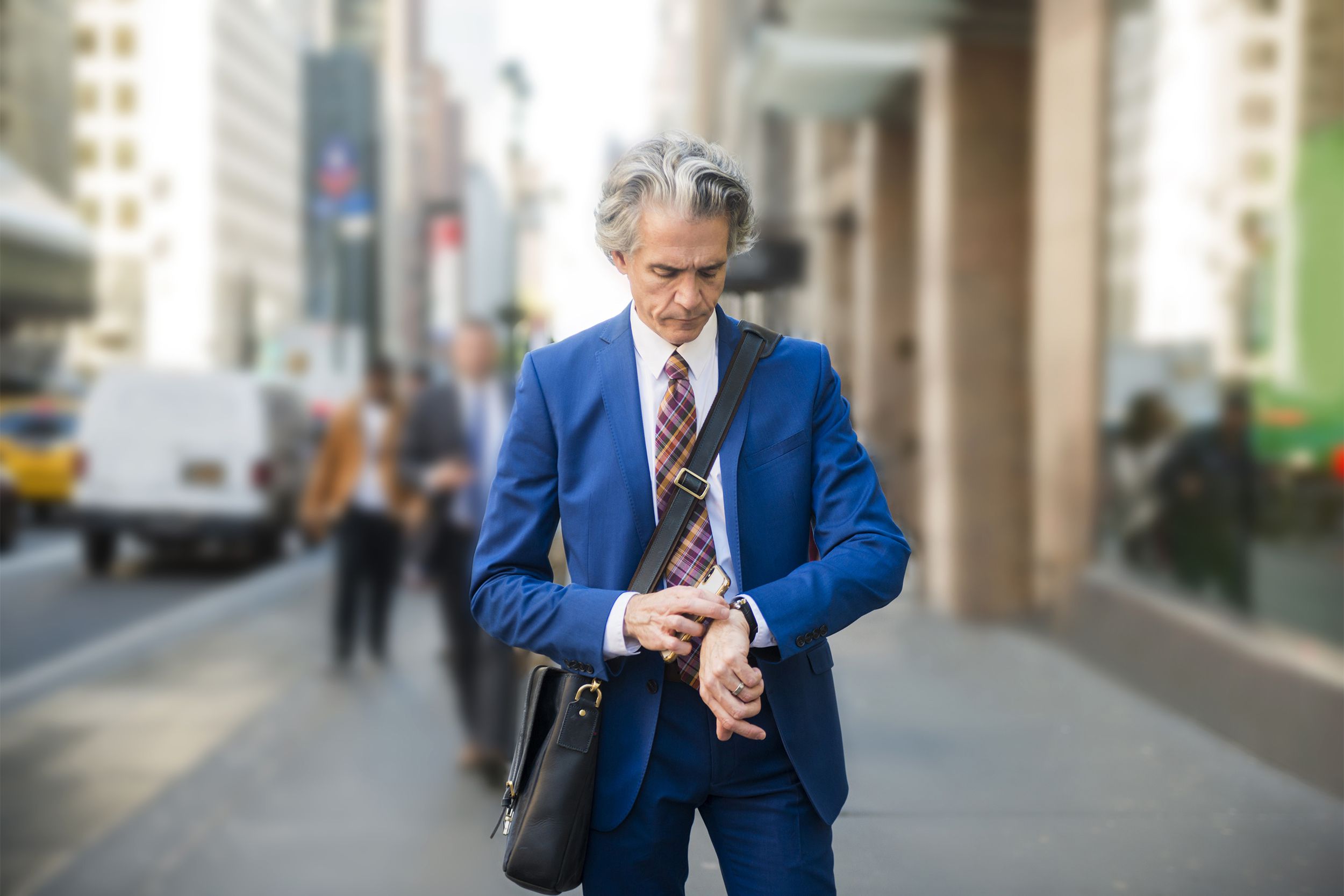 Older man in suit in New York looking at his watch