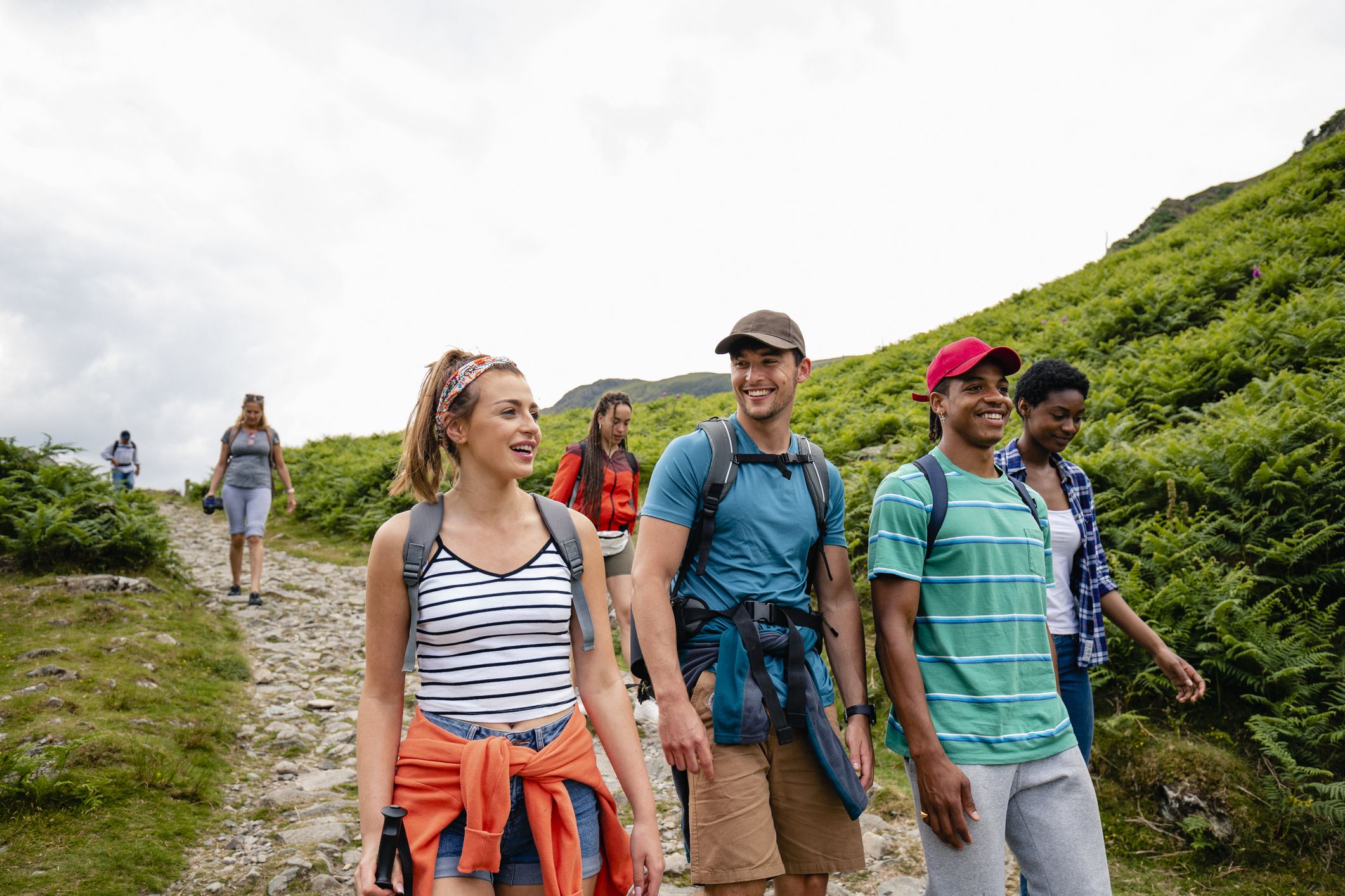 A group of young friends hiking down a footpath in The Lake District in Cumbria
