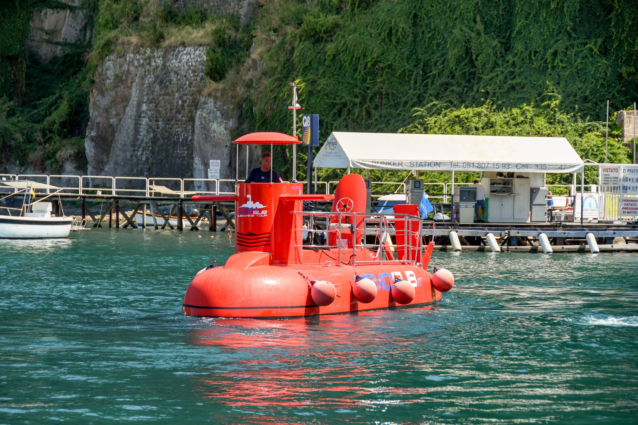 Sorrento, Italy - August 2019: Small red submarine in Sorrento harbour. It offers trips to tourists,