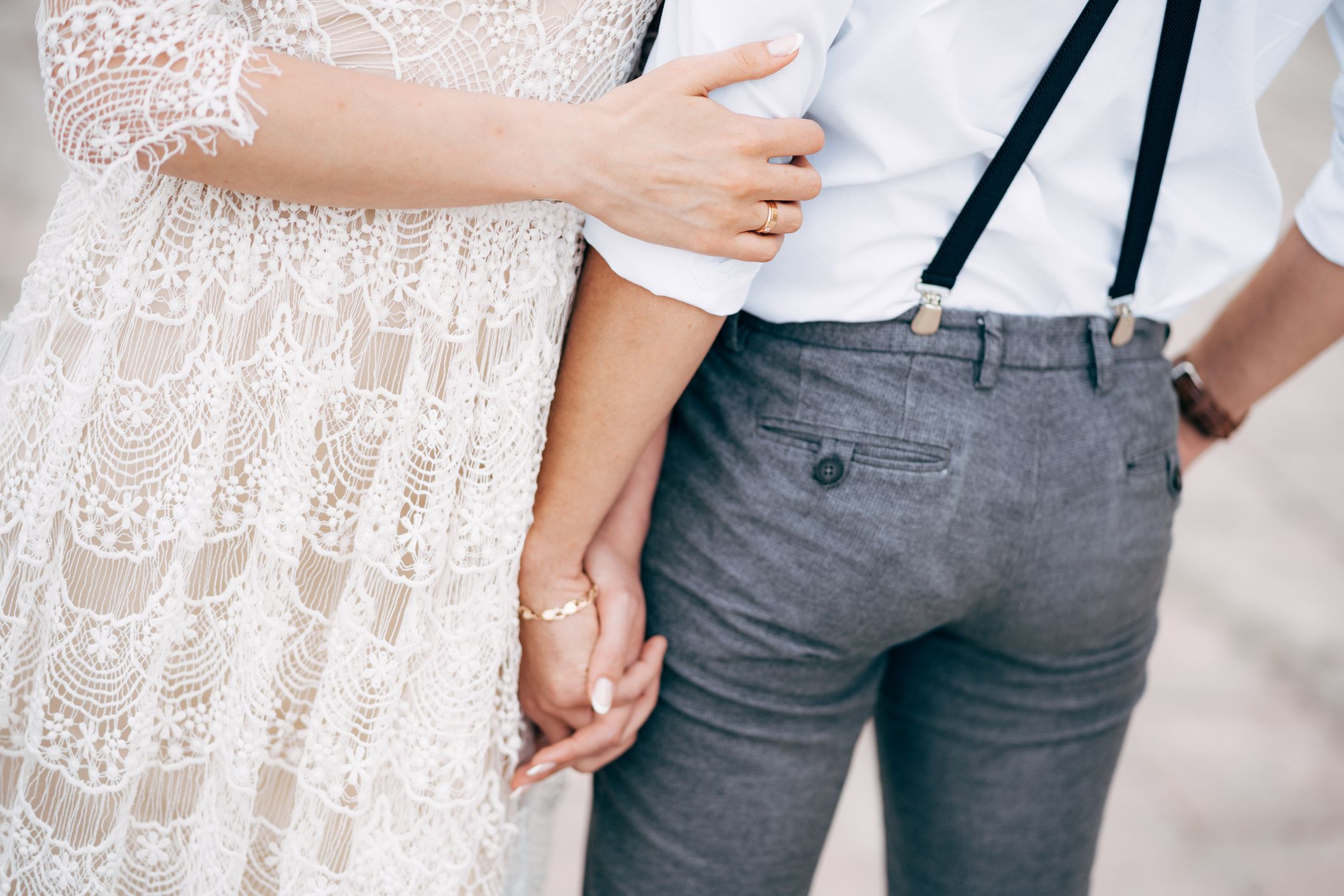 Bride stands next to groom and holds his hand. Bottom close-up view. High quality photo