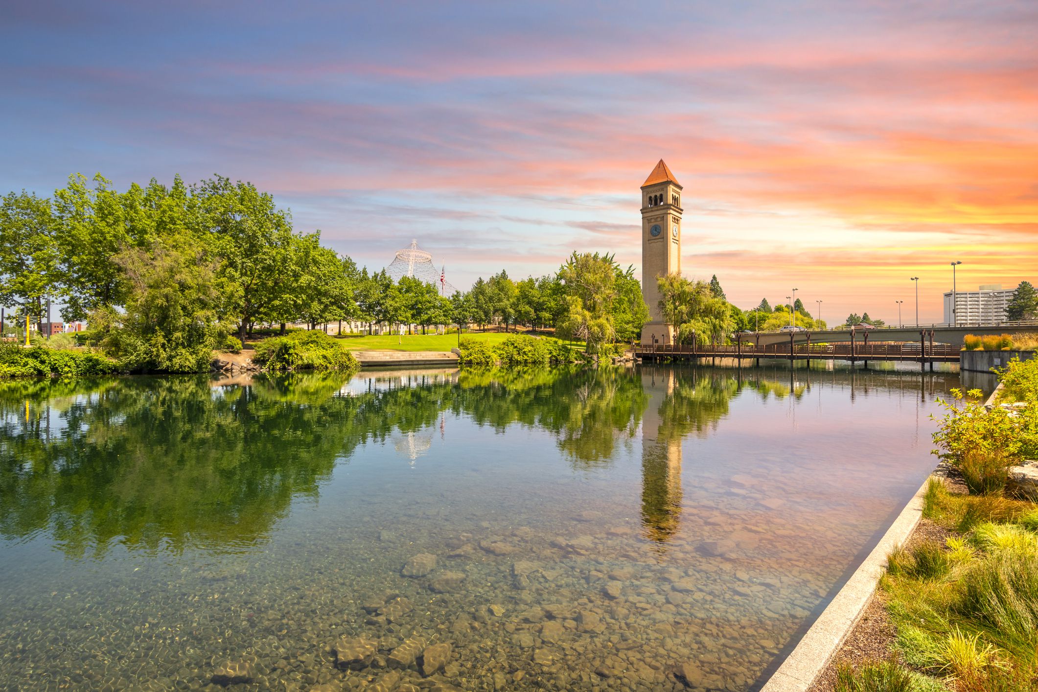The Spokane Clock Tower and Pavilion along the river in Riverfront Park, downtown Washington, under a colorful sunset in Spokane, Washington