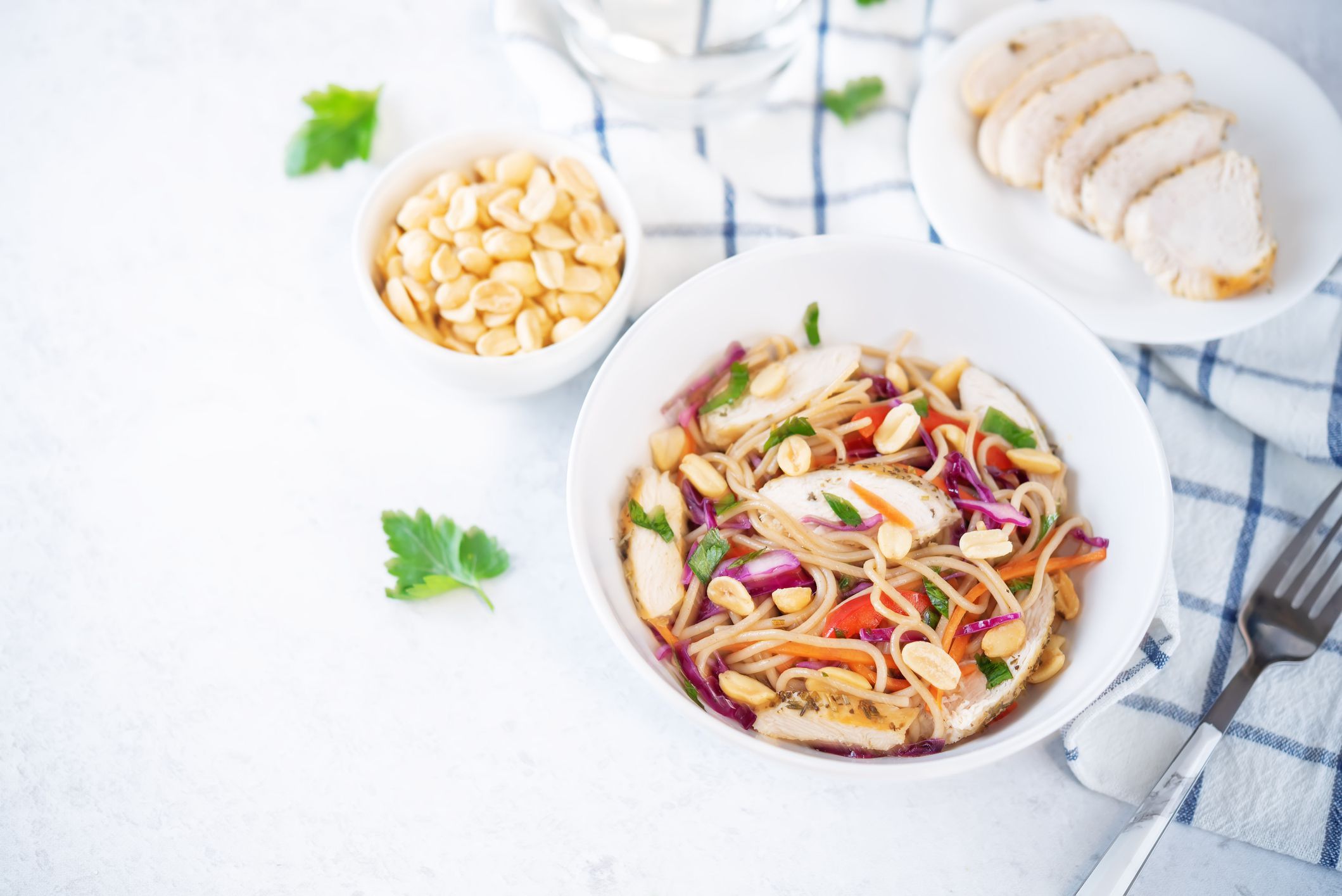 Warm backwheat pasta chicken vegetables salad with peanuts. toning. selective focus