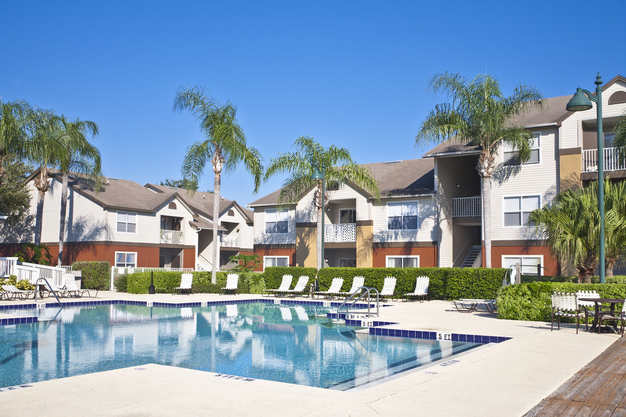 Condominium complex in the tropics with swimming pool, palmj trees and lush tropical foliage.
