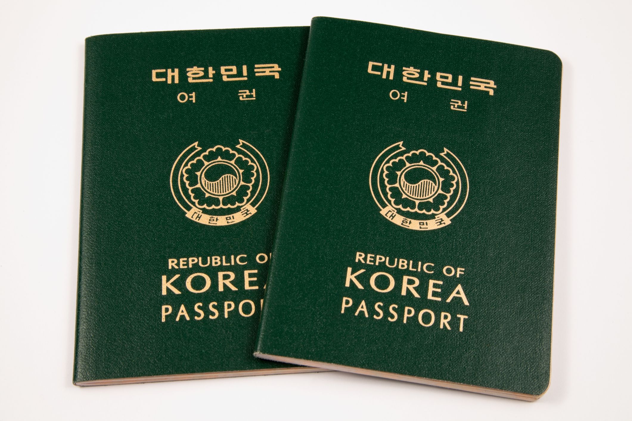 Two South Korean passports isolated on a white background.
