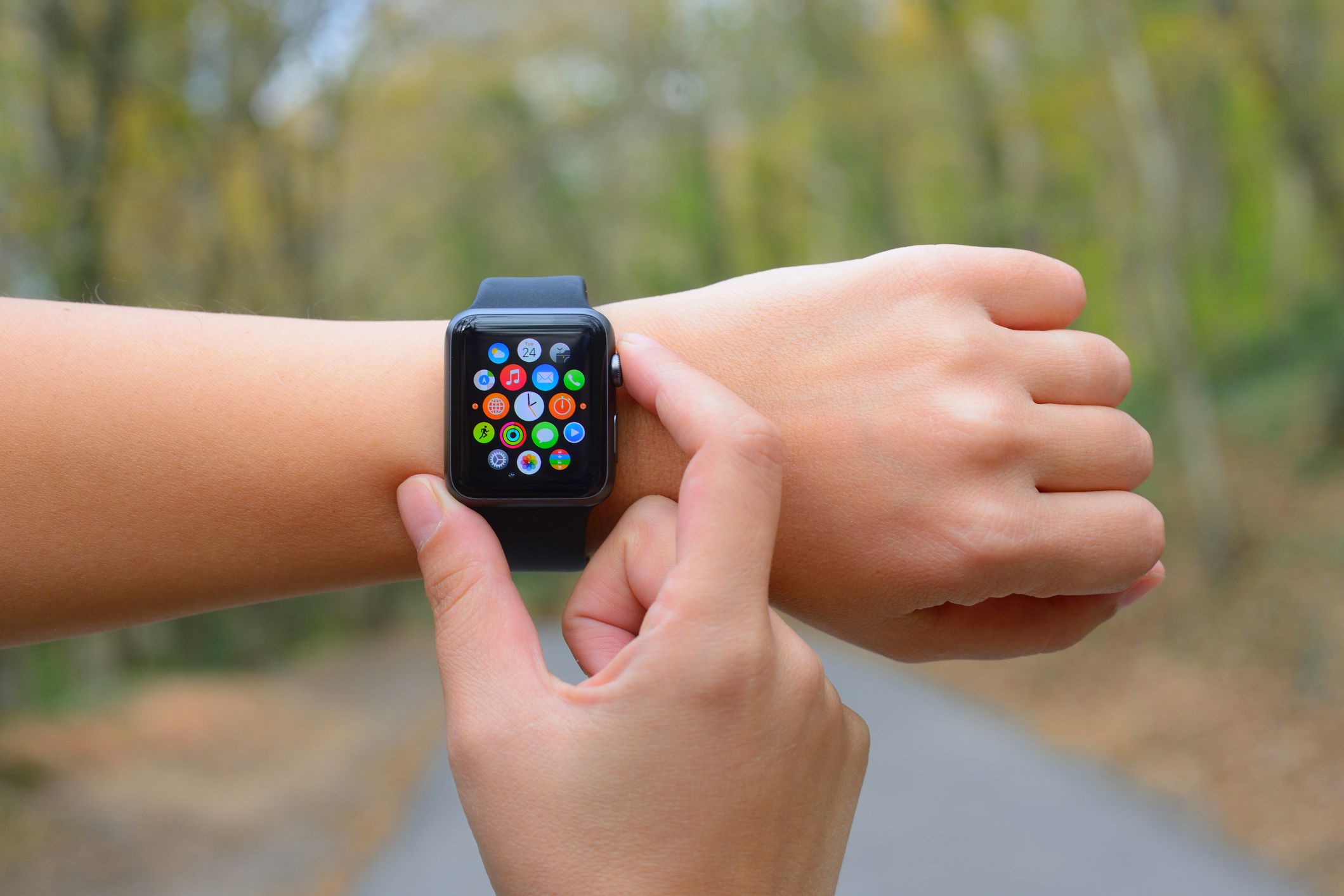 İstanbul, Turkey - November 24, 2015: Hand touching an Apple Watch displaying home screen in a park. Apple Watch is a smart watch, developed by Apple Inc.