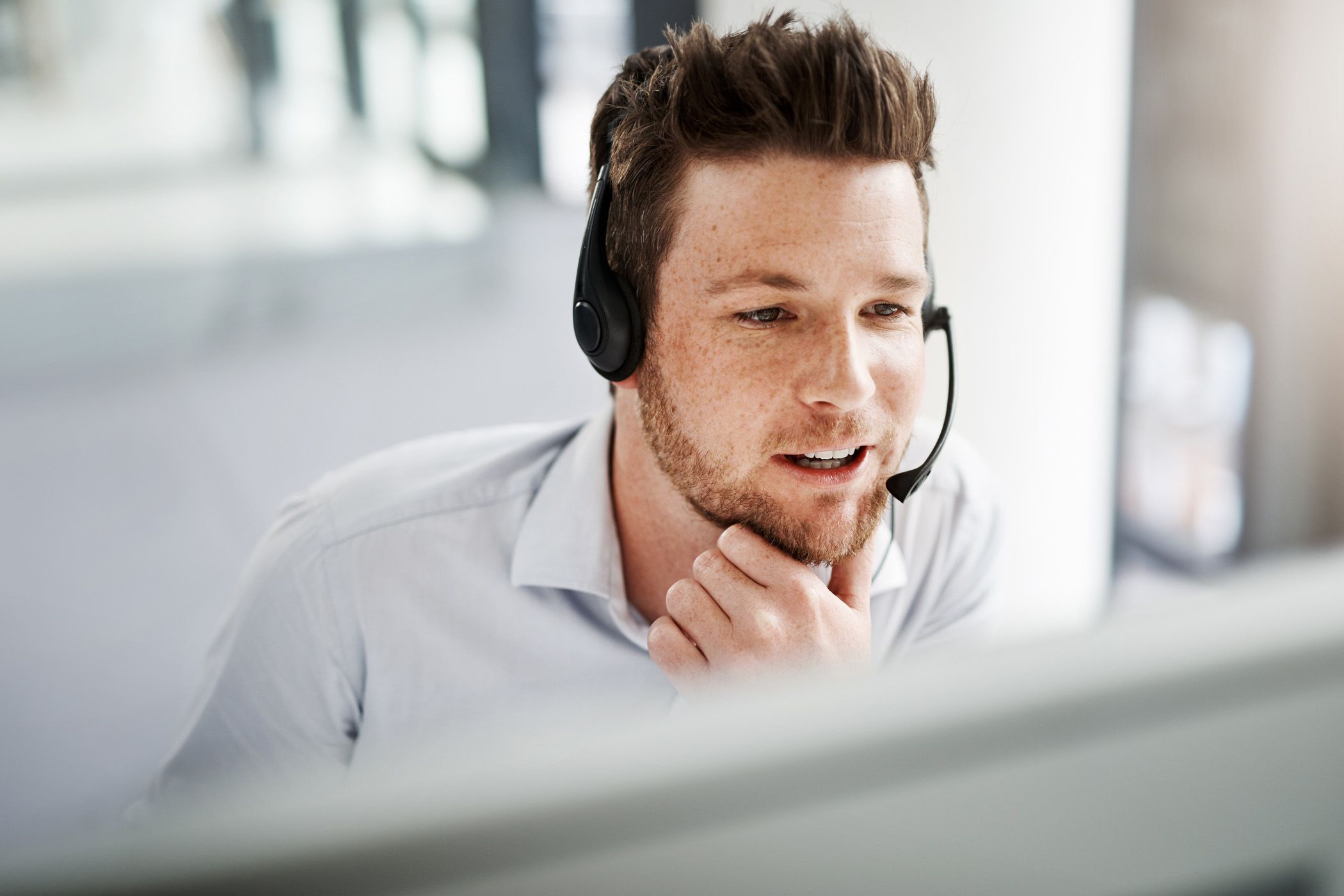man looking at screen wearing headset
