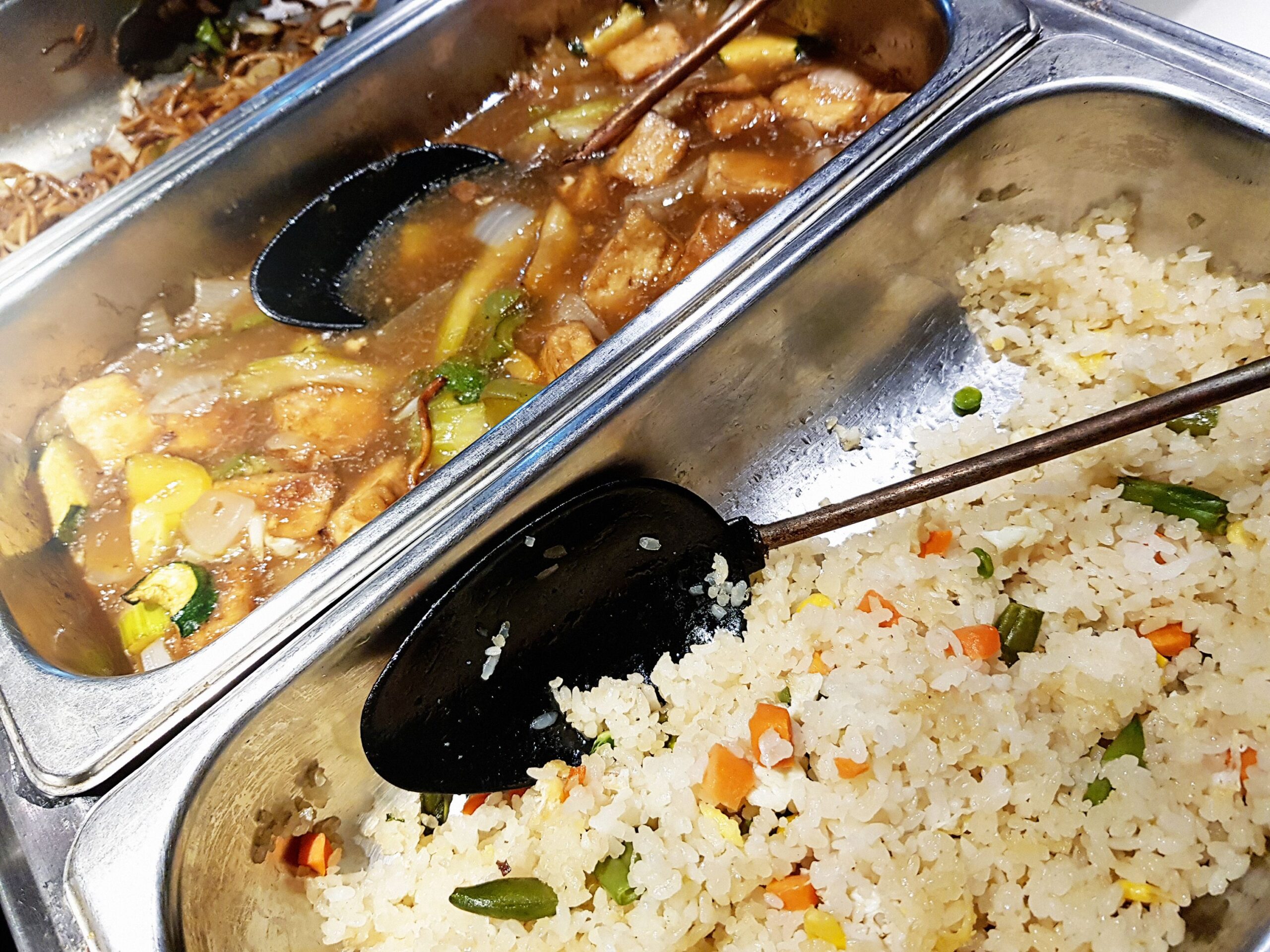 Looking down into the serving dishes at the buffet in a Chinese restaurant.
