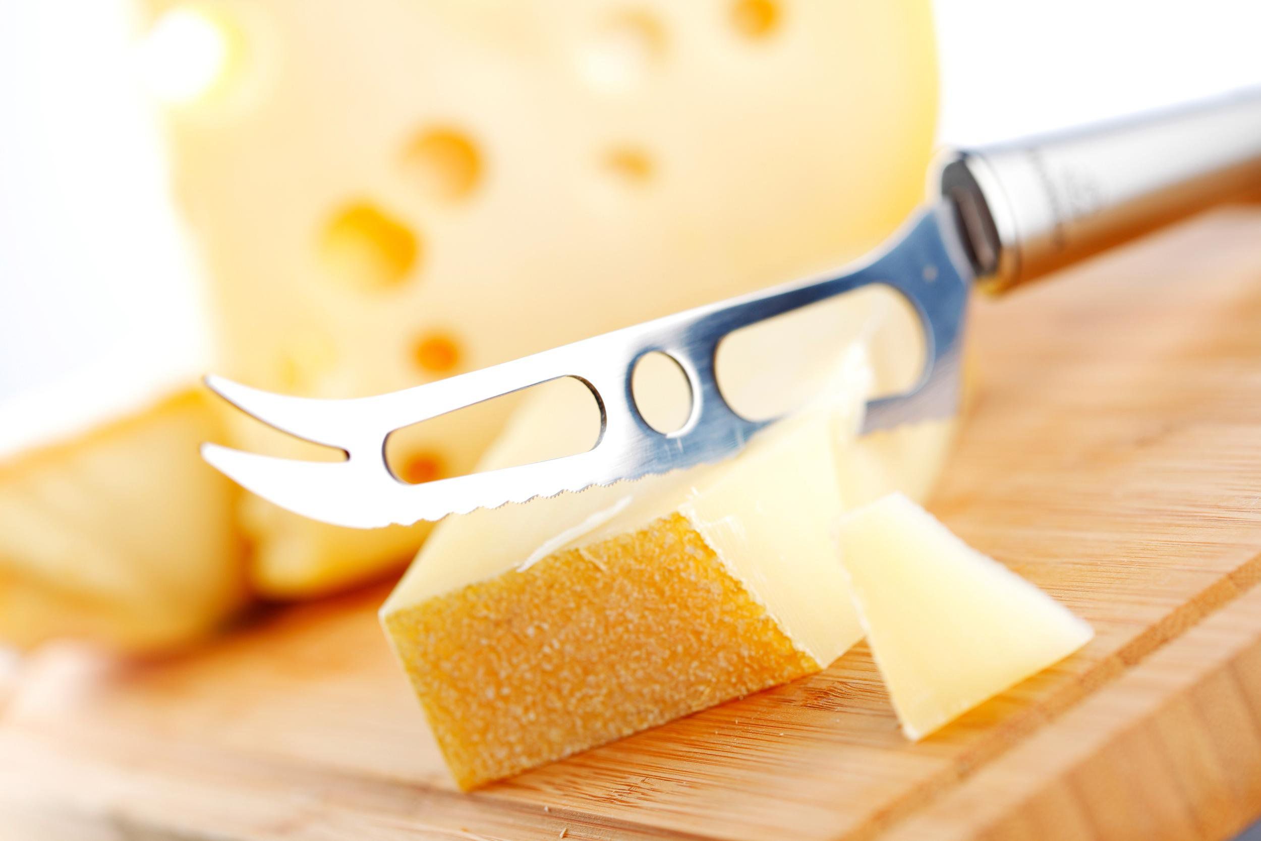 Cheese with a cheese knife on a cutting board