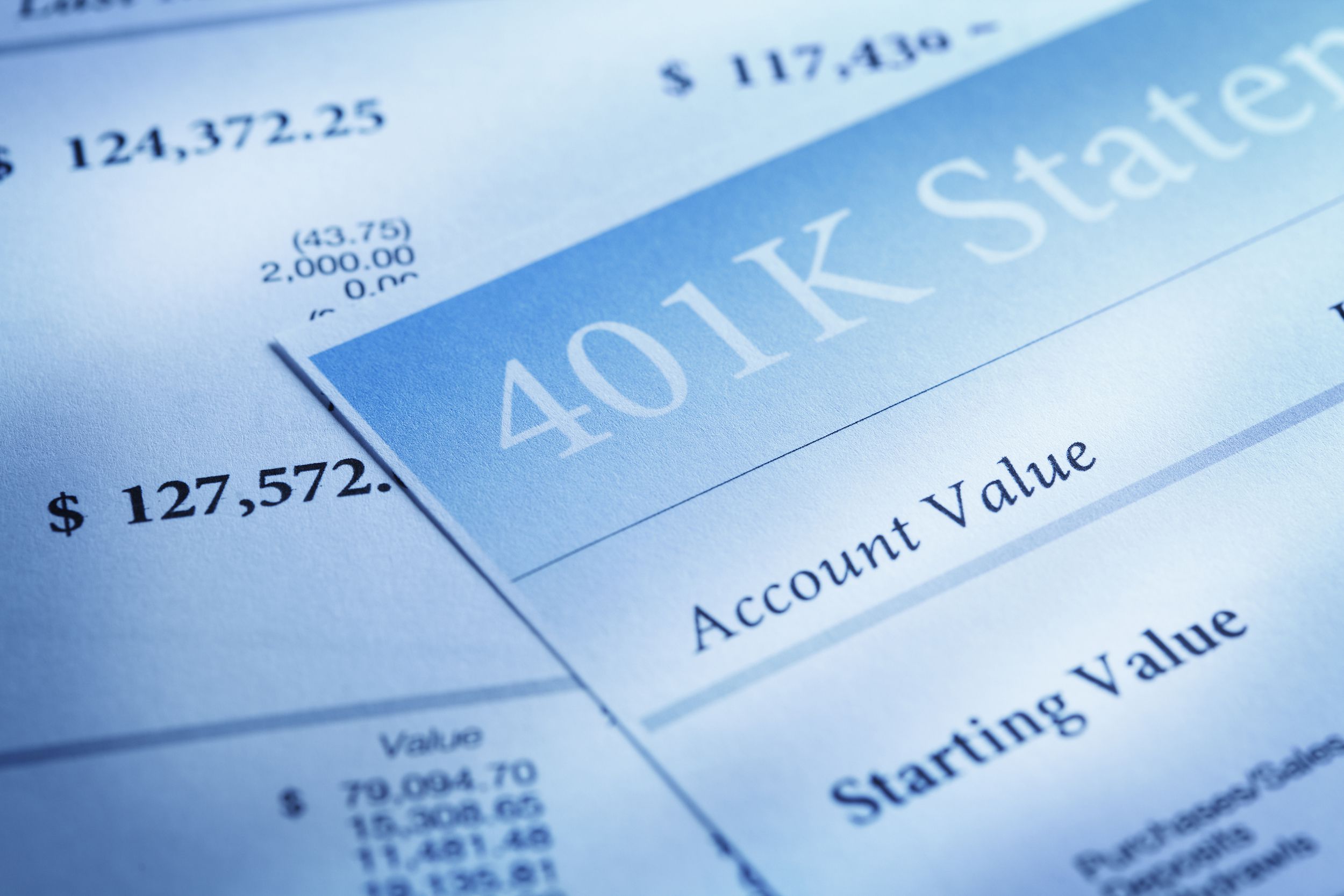Closeup of two 401K statements, both are blue-toned