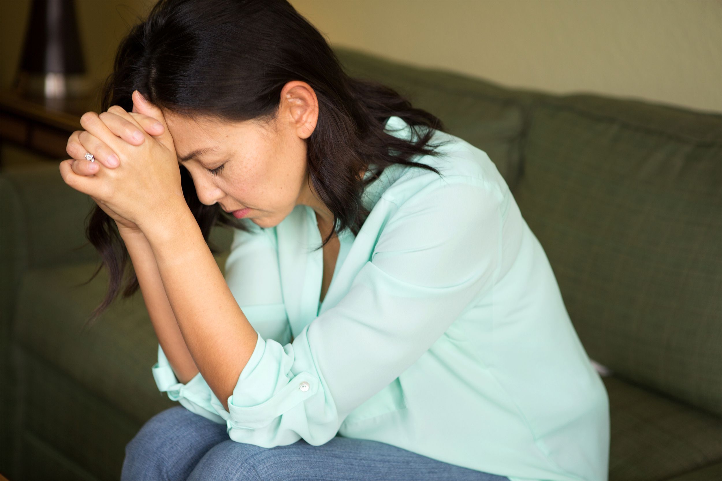 Middle aged woman sitting with her head in her hands