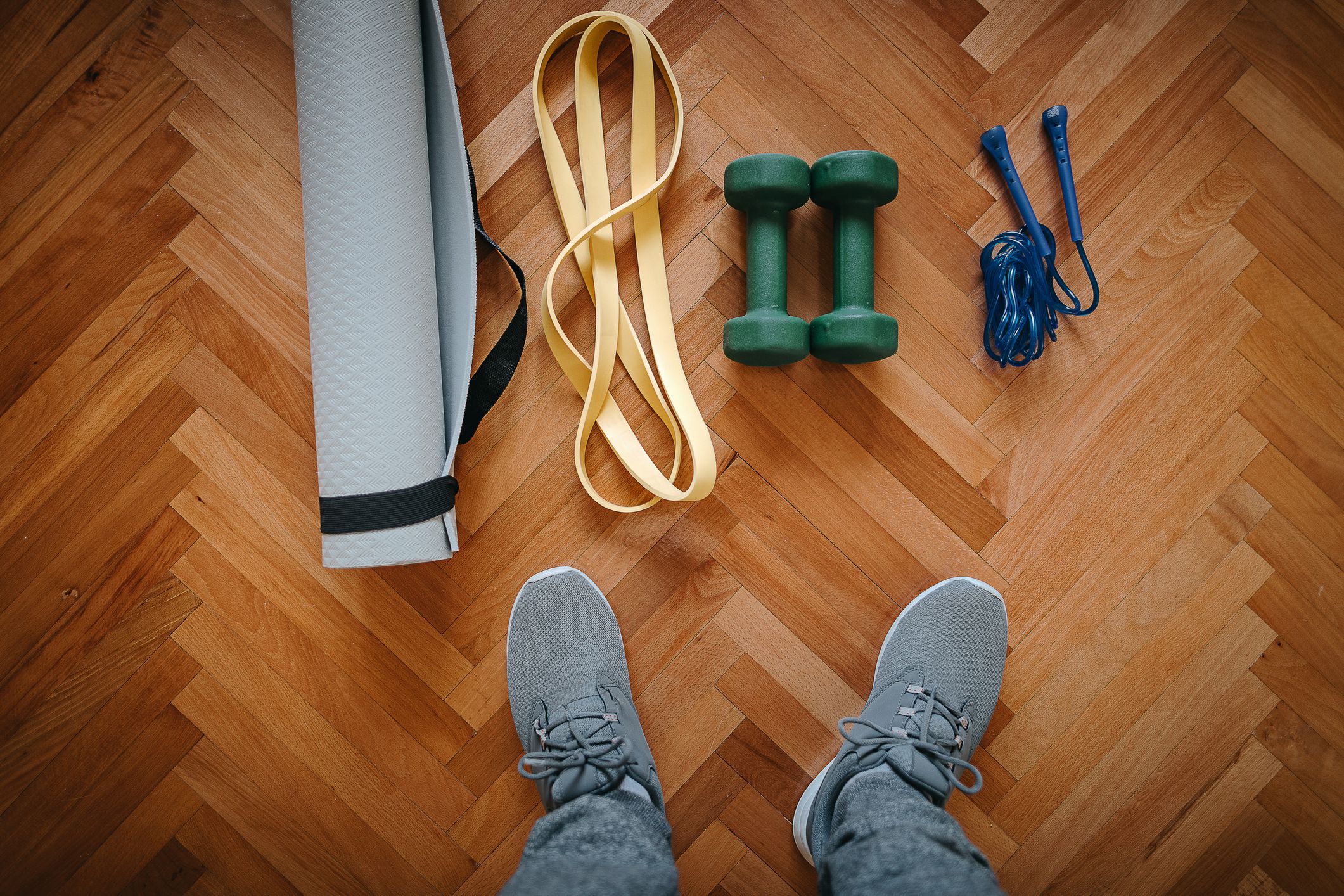Person looking down at exercise equipment on hardwood floor