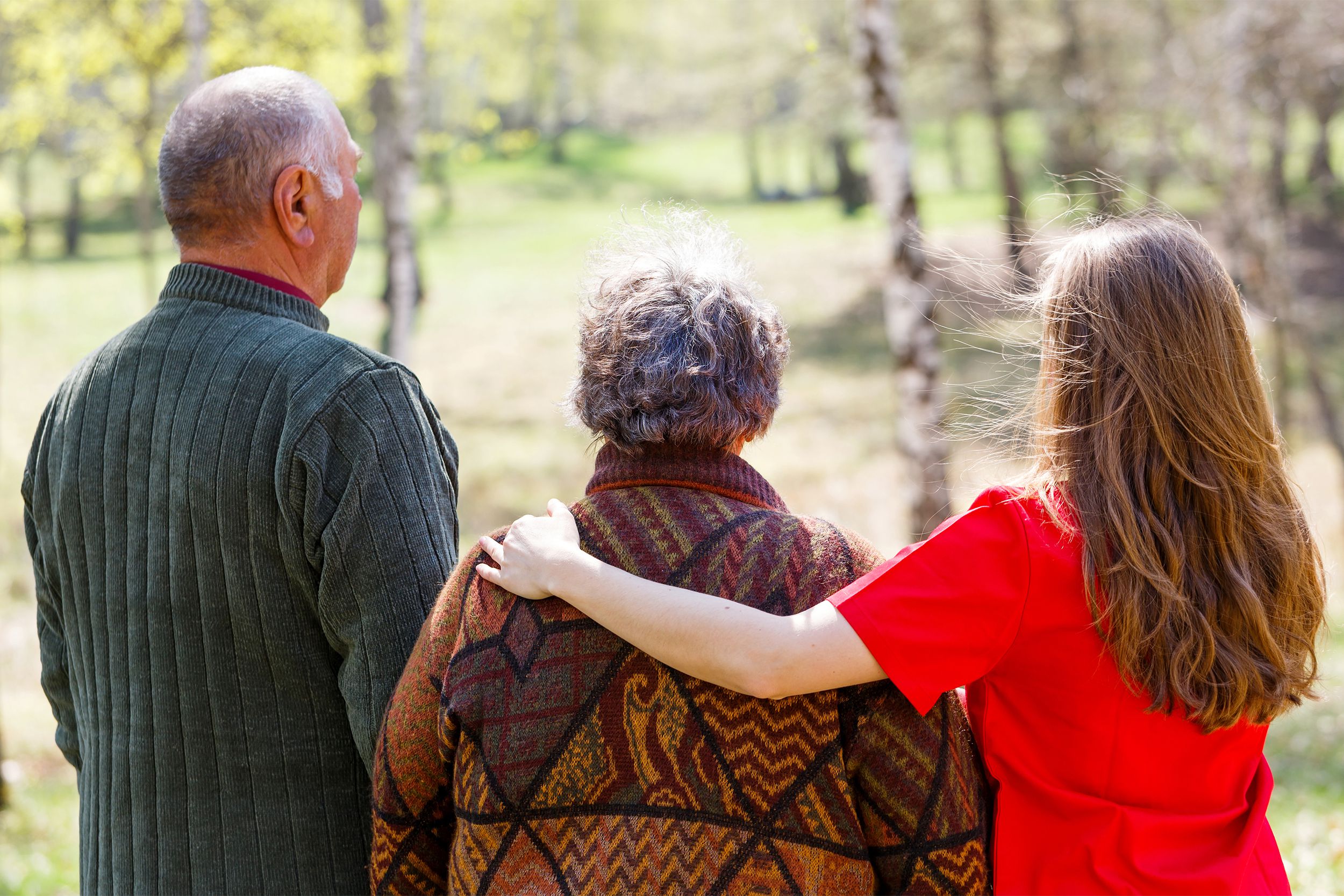 Young caregiver assisting an elderly couple