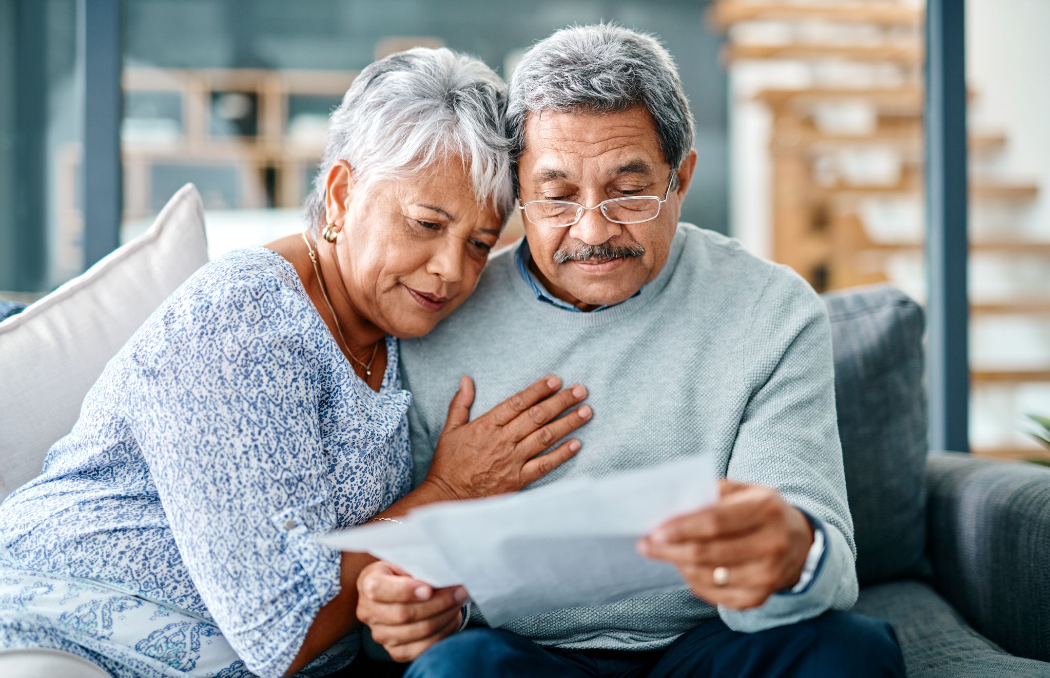 Shot of a mature couple looking worried while going through paperwork together at home