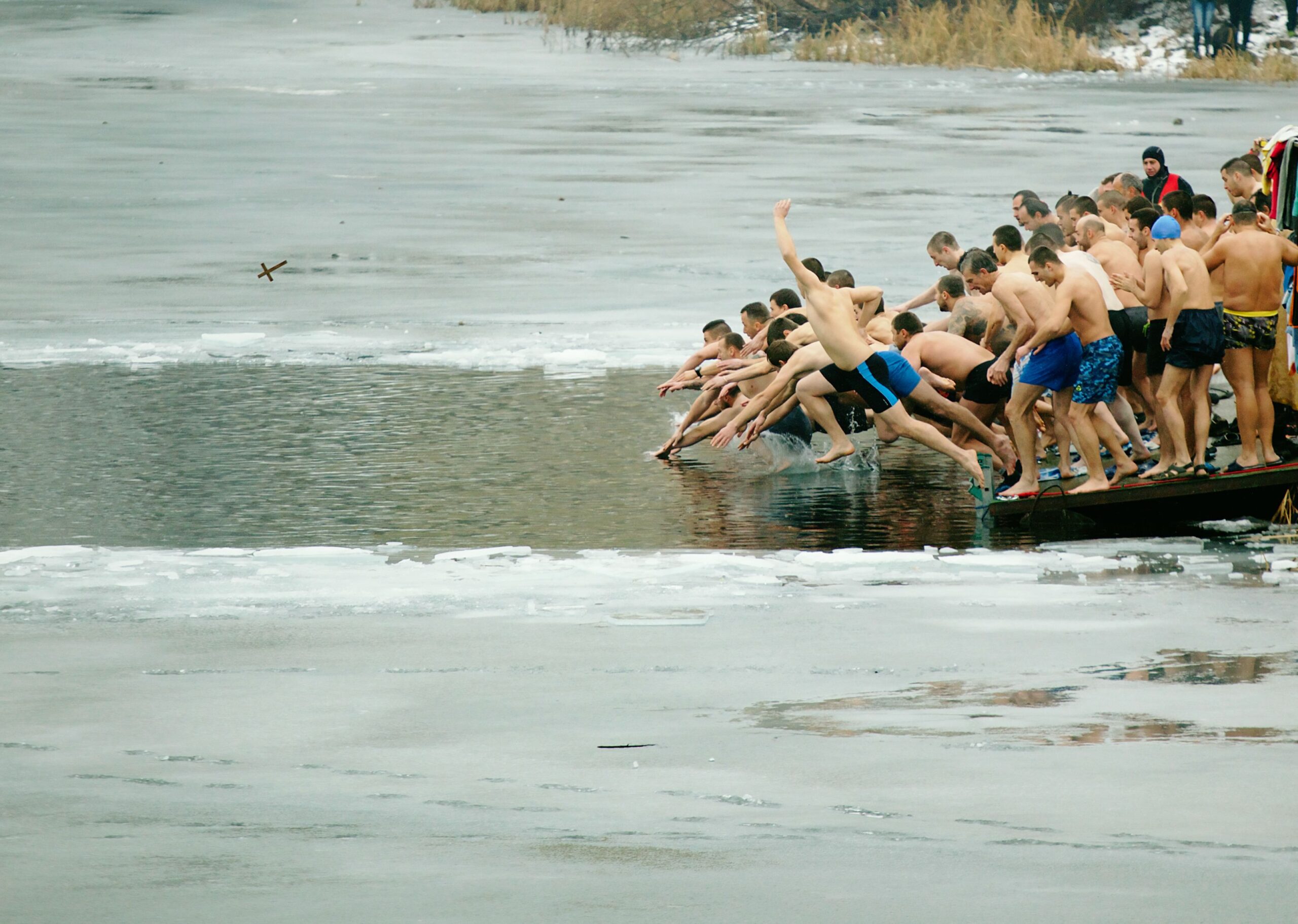 Sofia, Bulgaria - January 6, 2016: Many young men dive into the icy waters of Drujba lake to catch a holy cross as part of Epiphany Day celebrations.