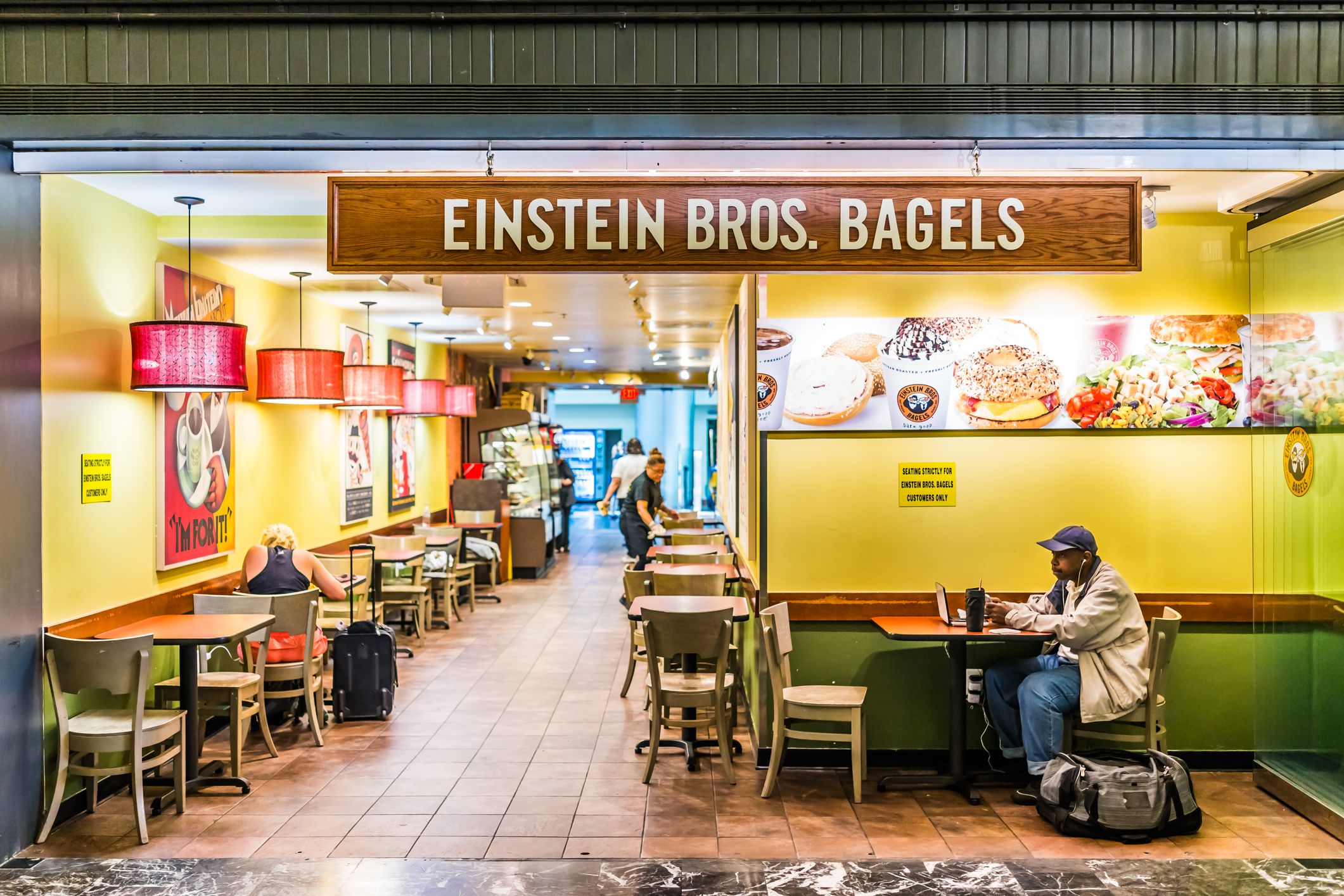 Washington Dc: Inside Union Station in capital city with shopping mall food court and Einstein Brothers Bagels restaurant sign