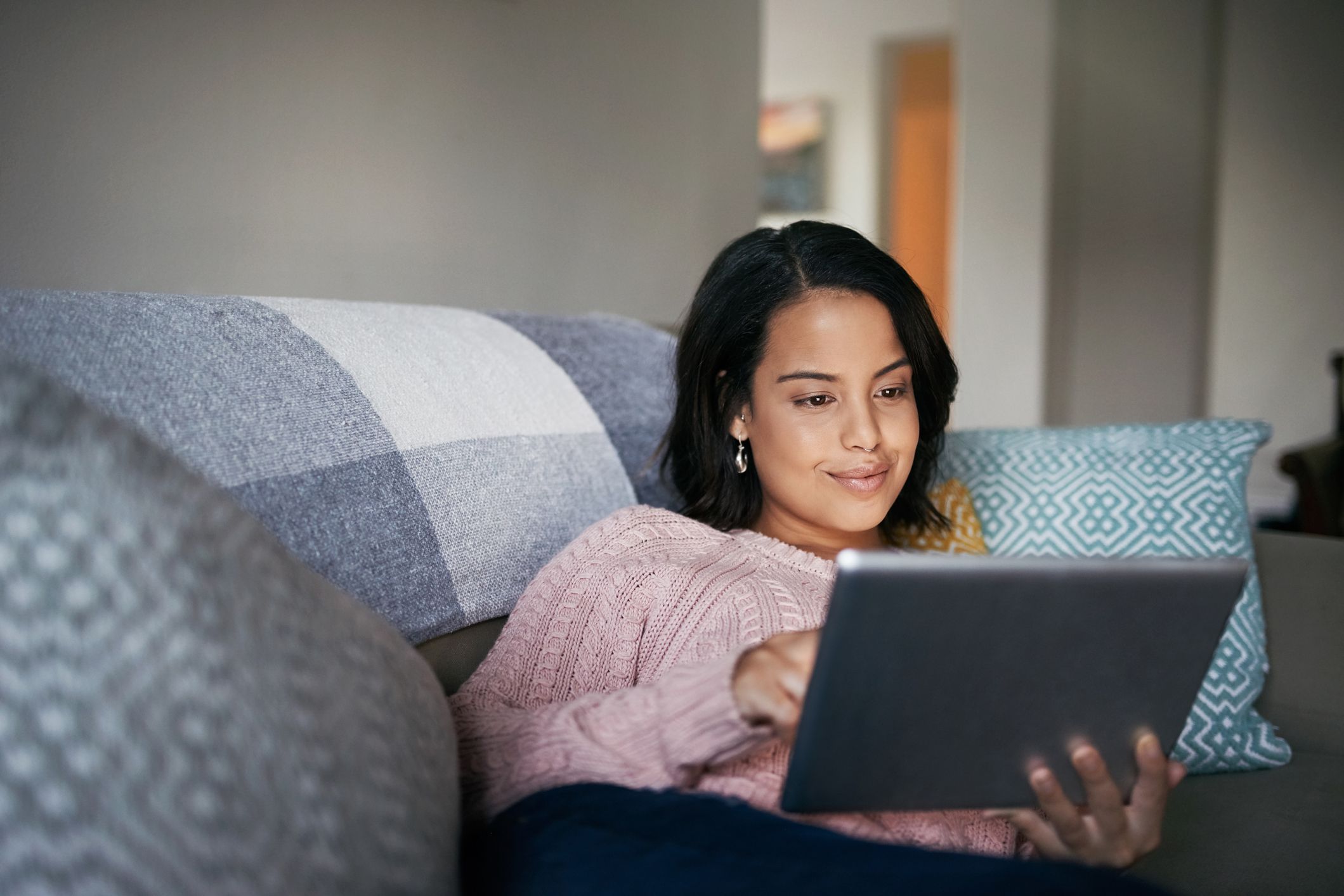 Shot of an attractive young woman using a digital tablet at home