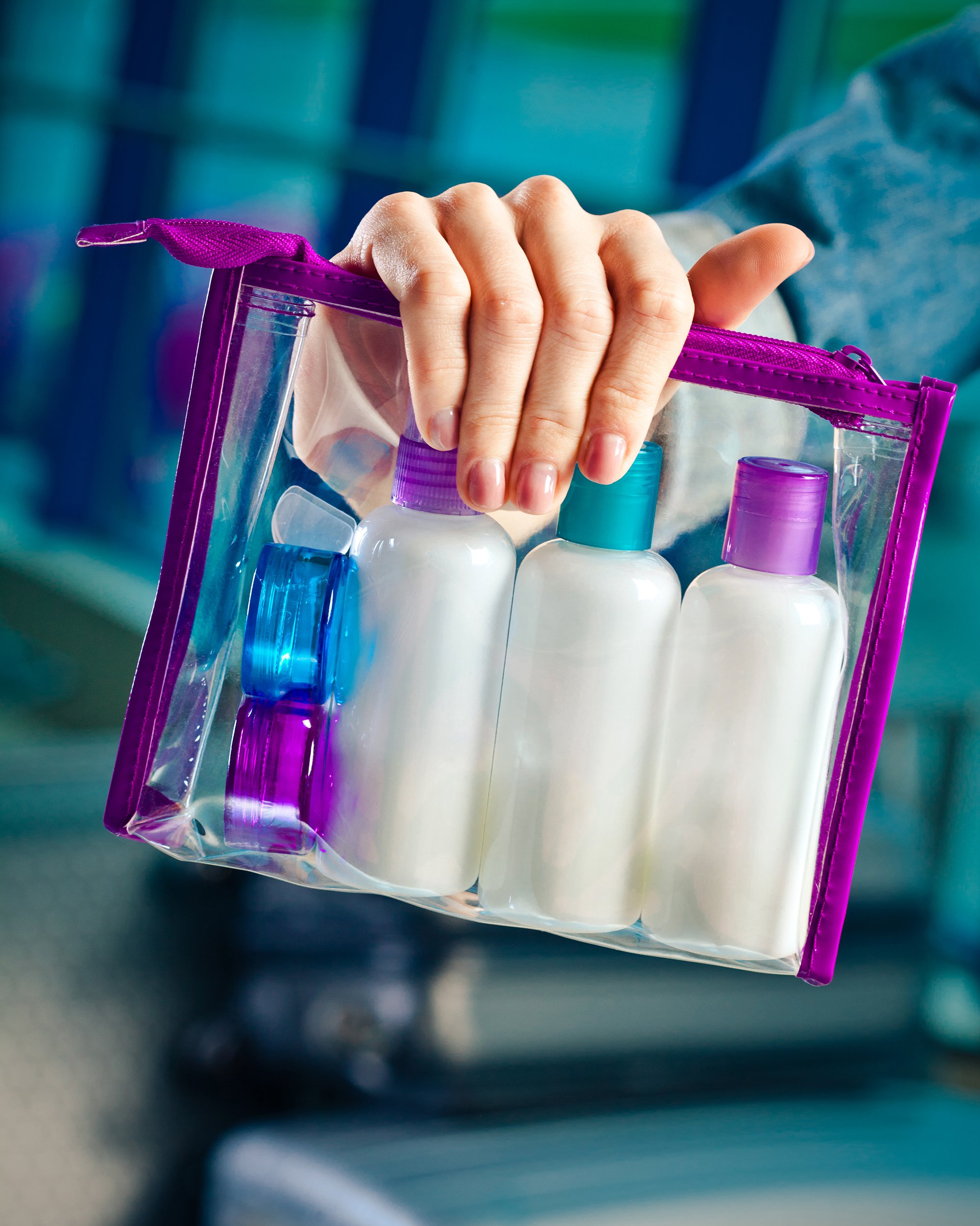 hand holding onto bag of travel toiletries