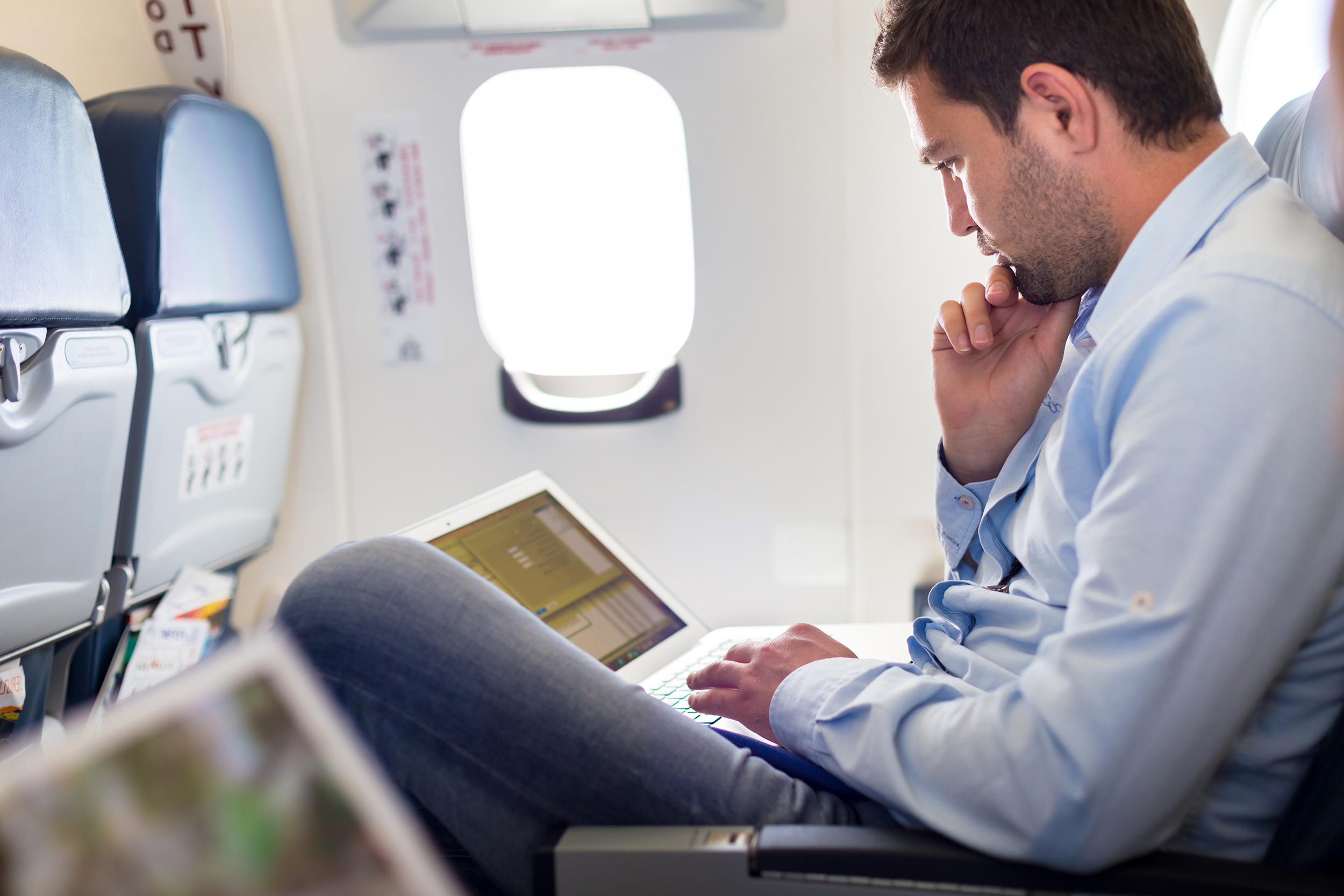 Man using his laptop on an airplane