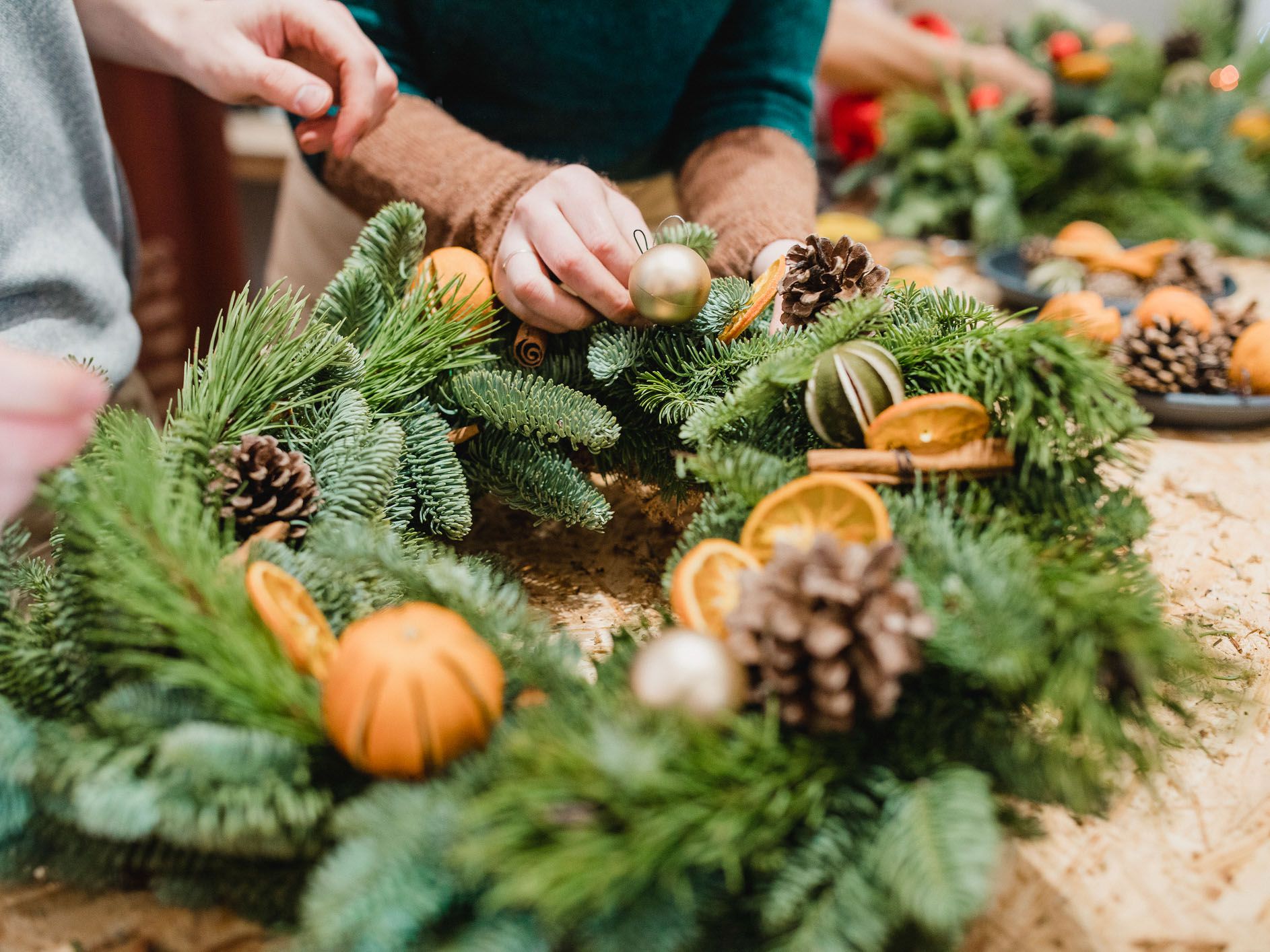 Close up shot of floristsdesigning a christmas wreath.