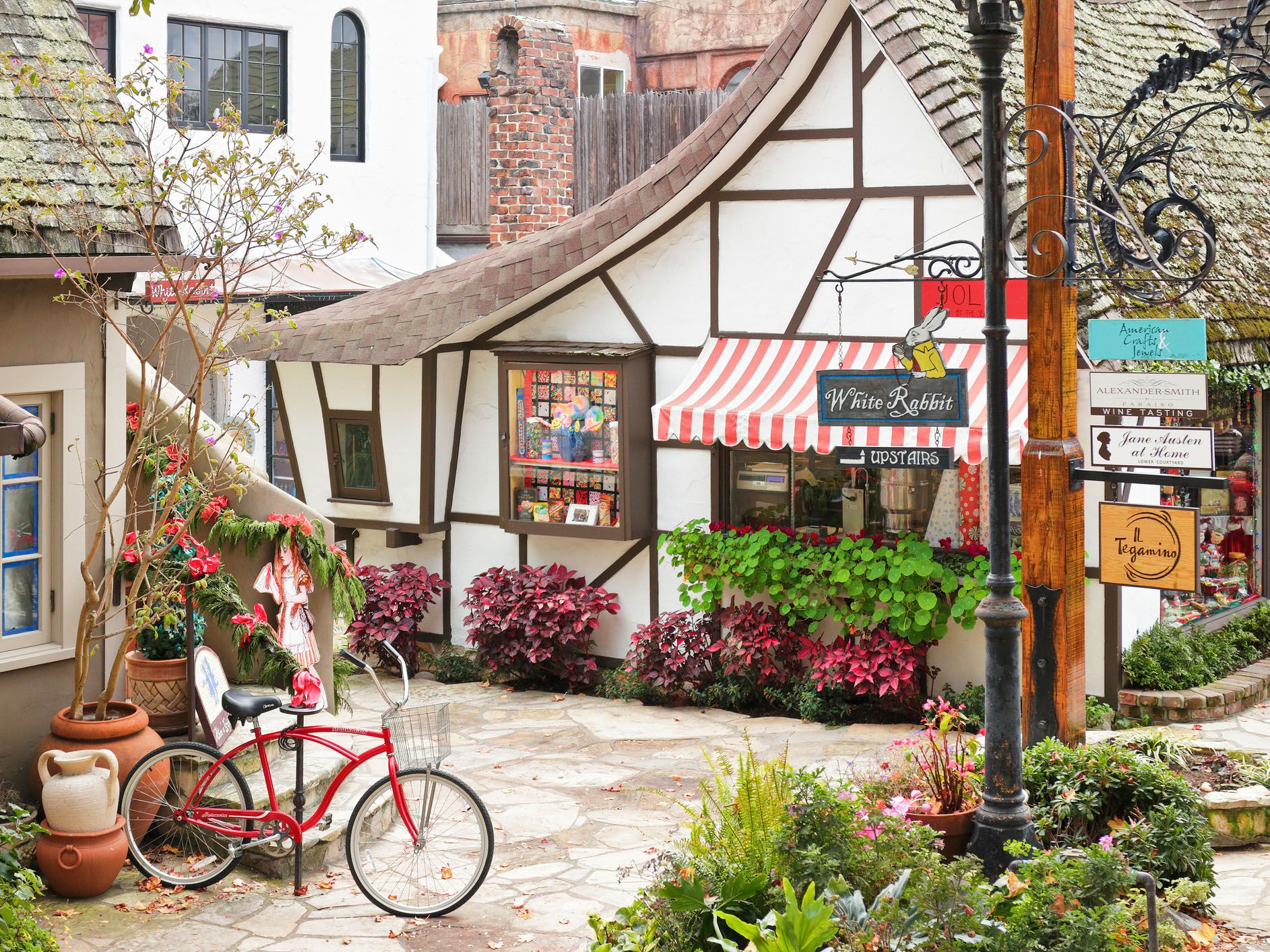 A streetscape in Carmel-by-the-Sea featuring a retail shop housed in a typical fairytale cottage - style architecture.