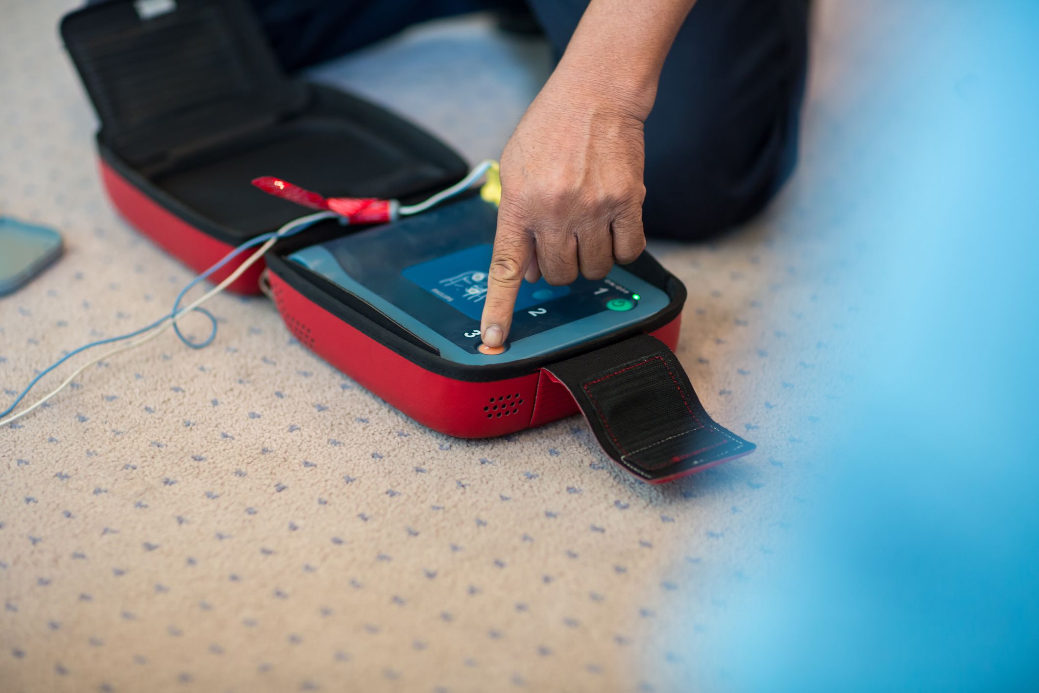 CPR training using and an AED and bag mask valve on an adult training manikin. First aid cardiopulmonary resuscitation course using automated external defibrillator device, AED.