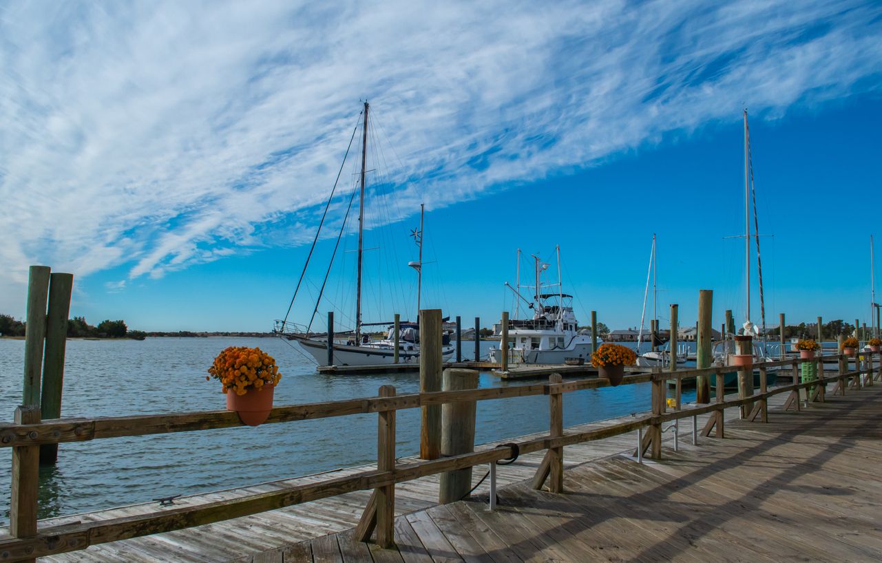 The blues get bluer when the weather is cold in Beaufort, North Carolina. A historic waterfront destination, known for tall ships, calm waters, and a relaxing lifestyle. Closeup of sailing ships and the rigs, background images, inspirational clouds in the