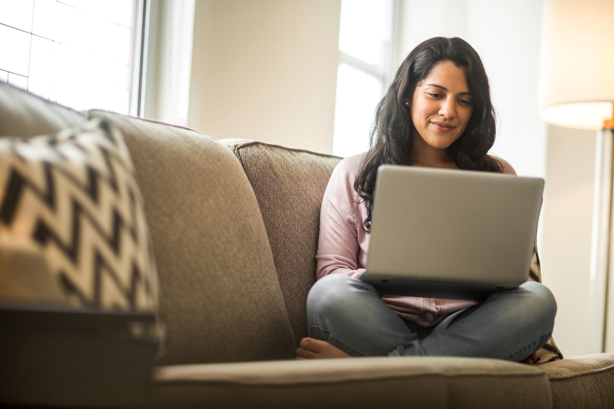 Latin woman working on a laptop doing her budget.